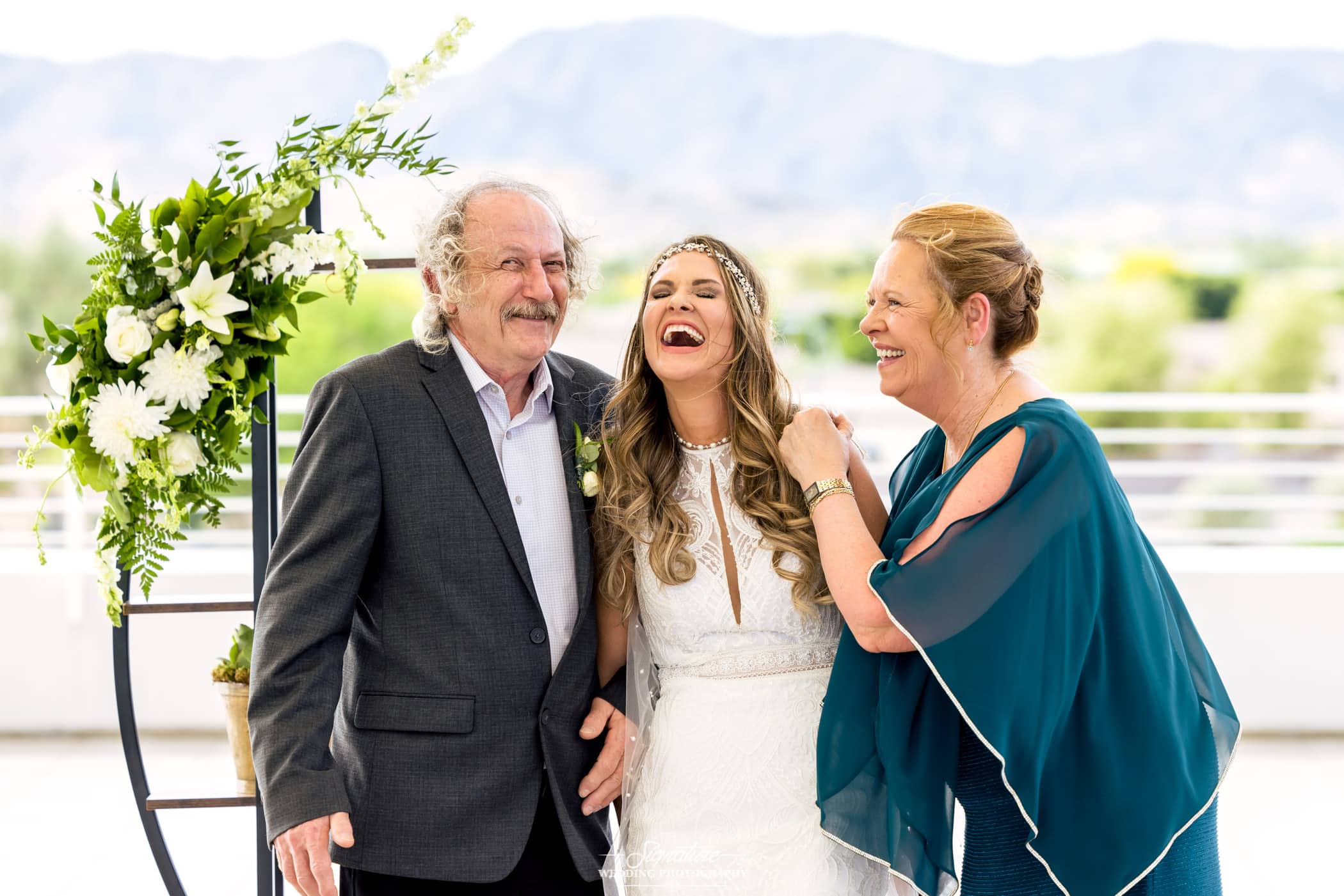 Bride laughing with parents