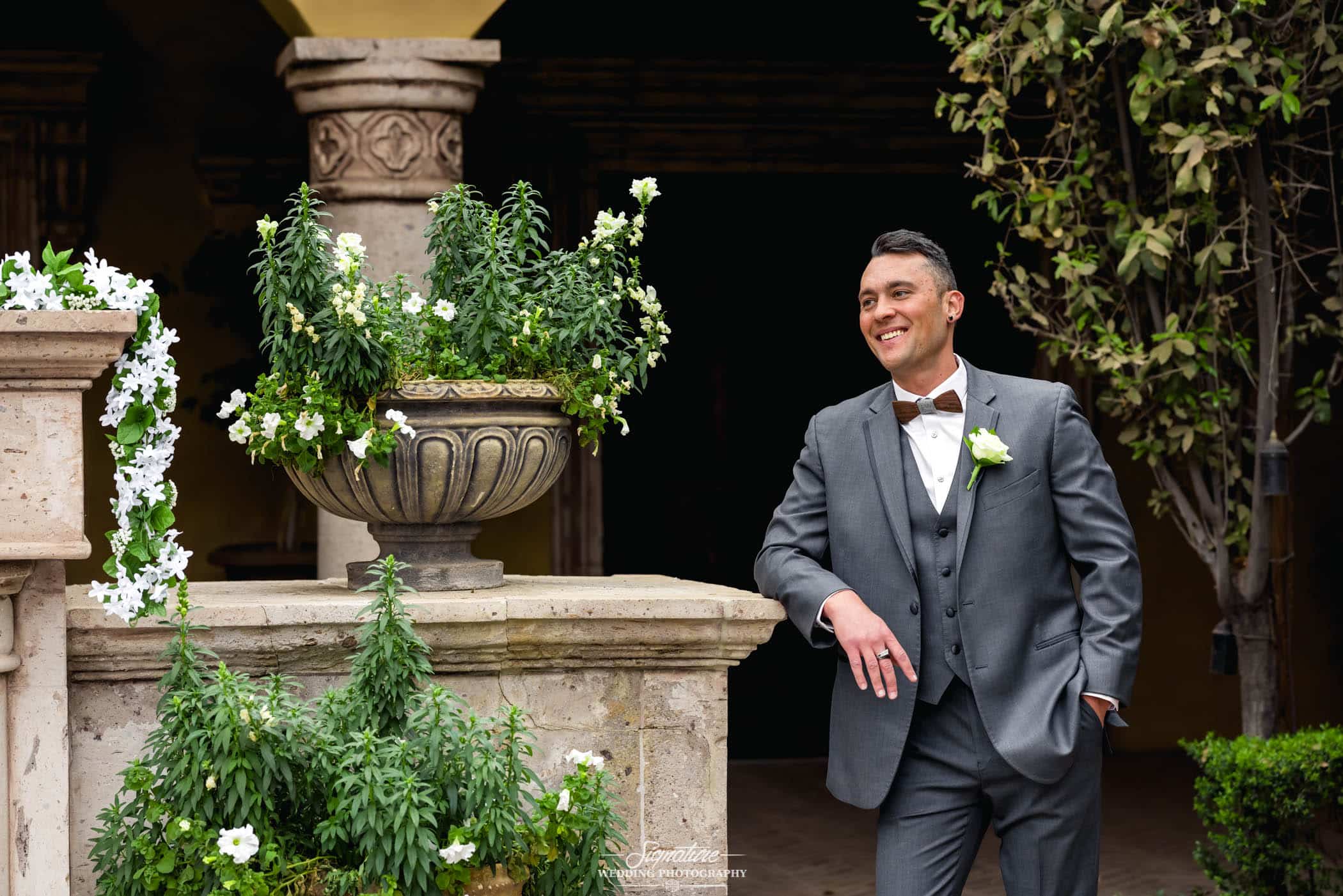 Groom's arm on ledge smiling looking off camera