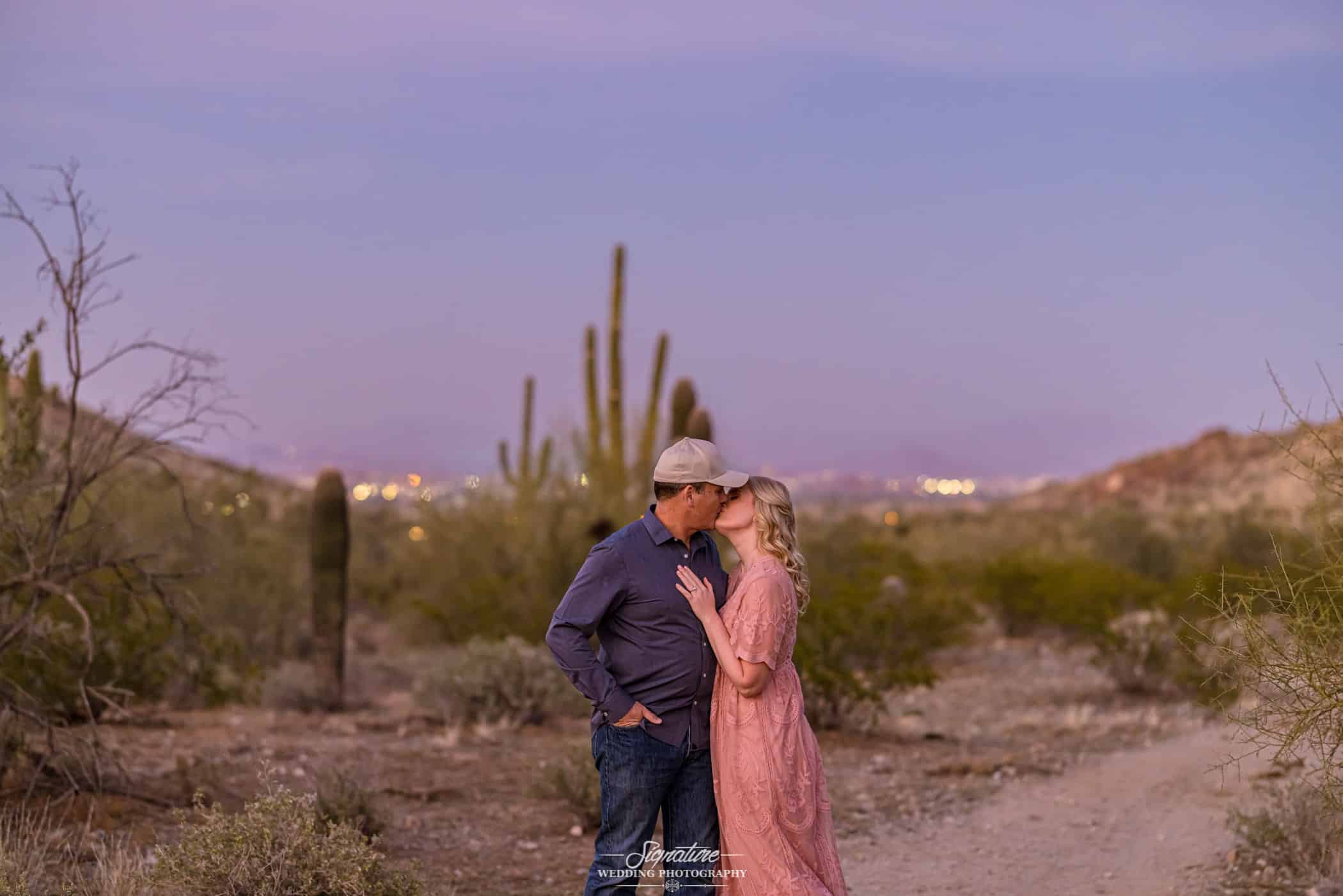Couple kissing in desert at sunset
