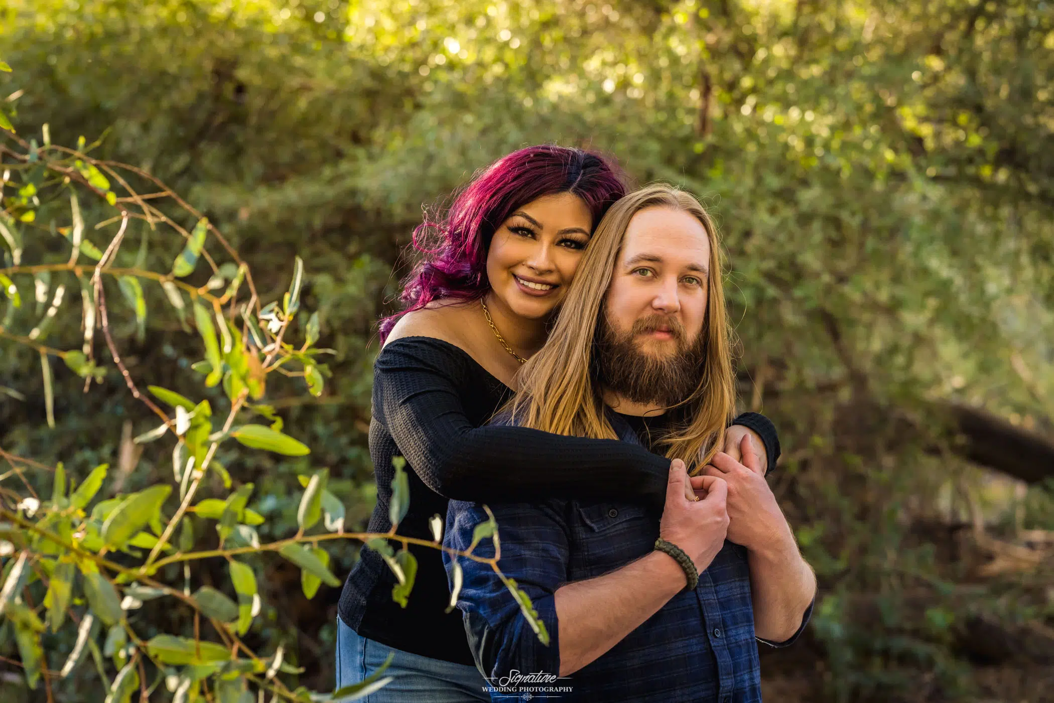 Woman hugging man's shoulders from behind smiling