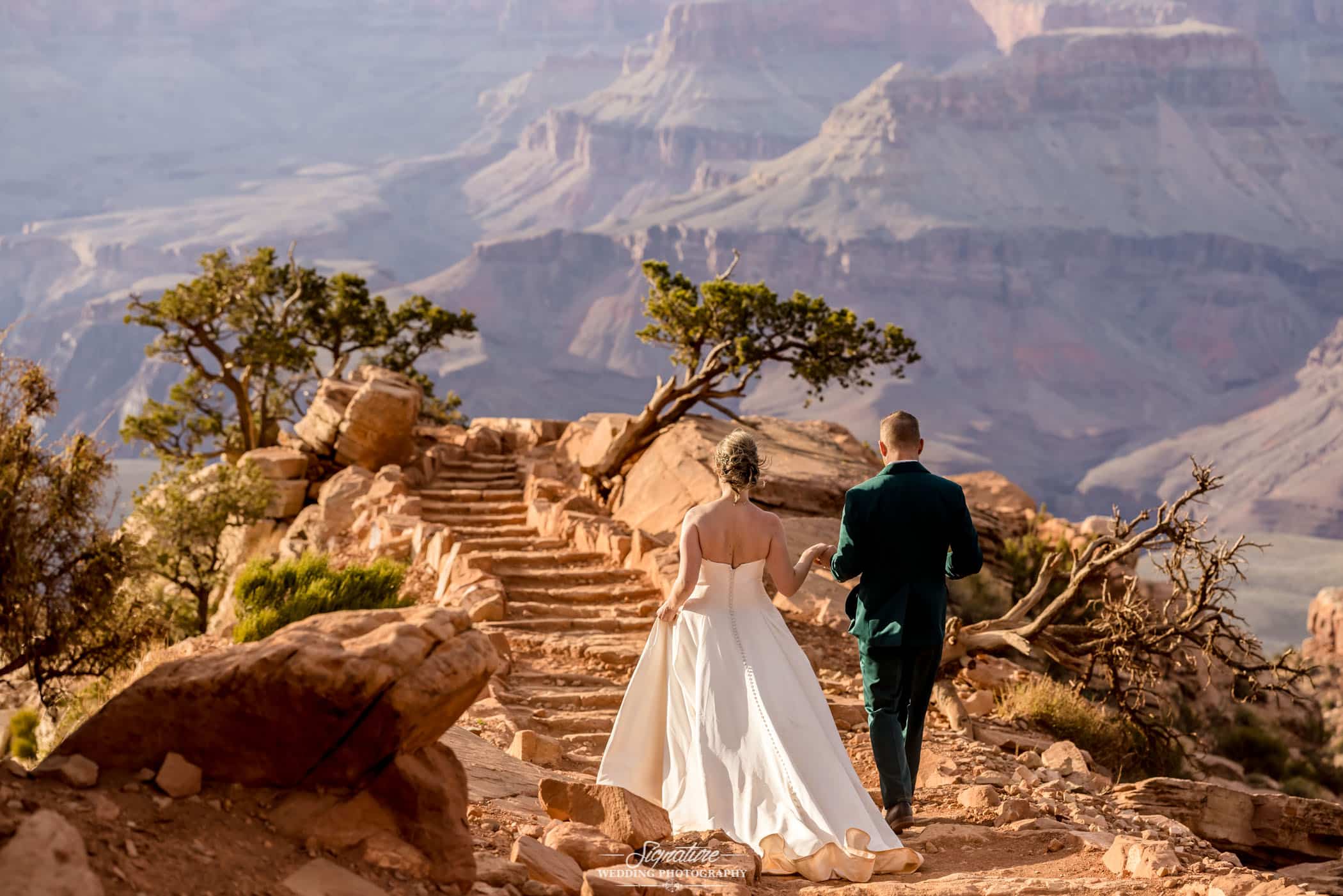 Bride and groom walking up mountain steps