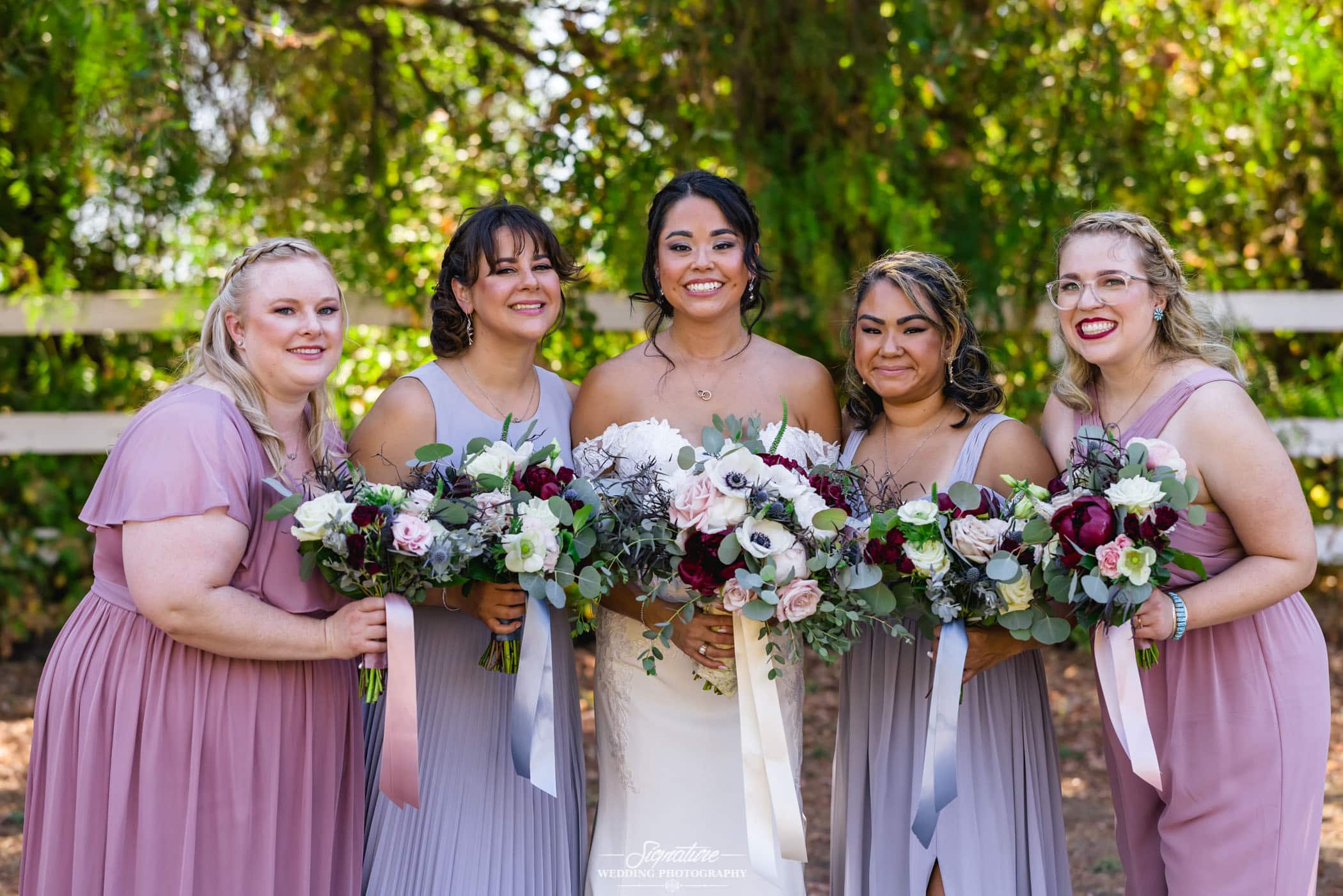 Bride and bridesmaids smiling with bouquets