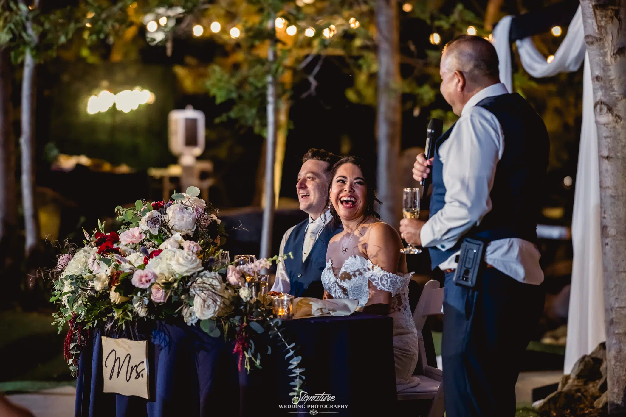 Bride and groom laughing at best man speech
