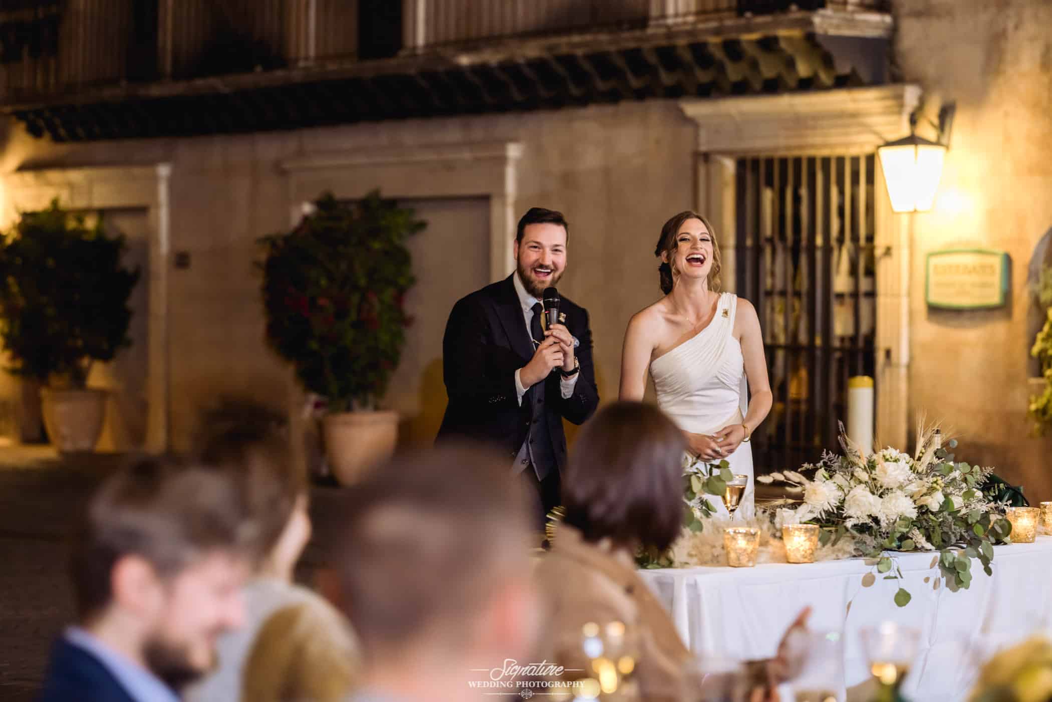 Bride and groom laughing with microphone