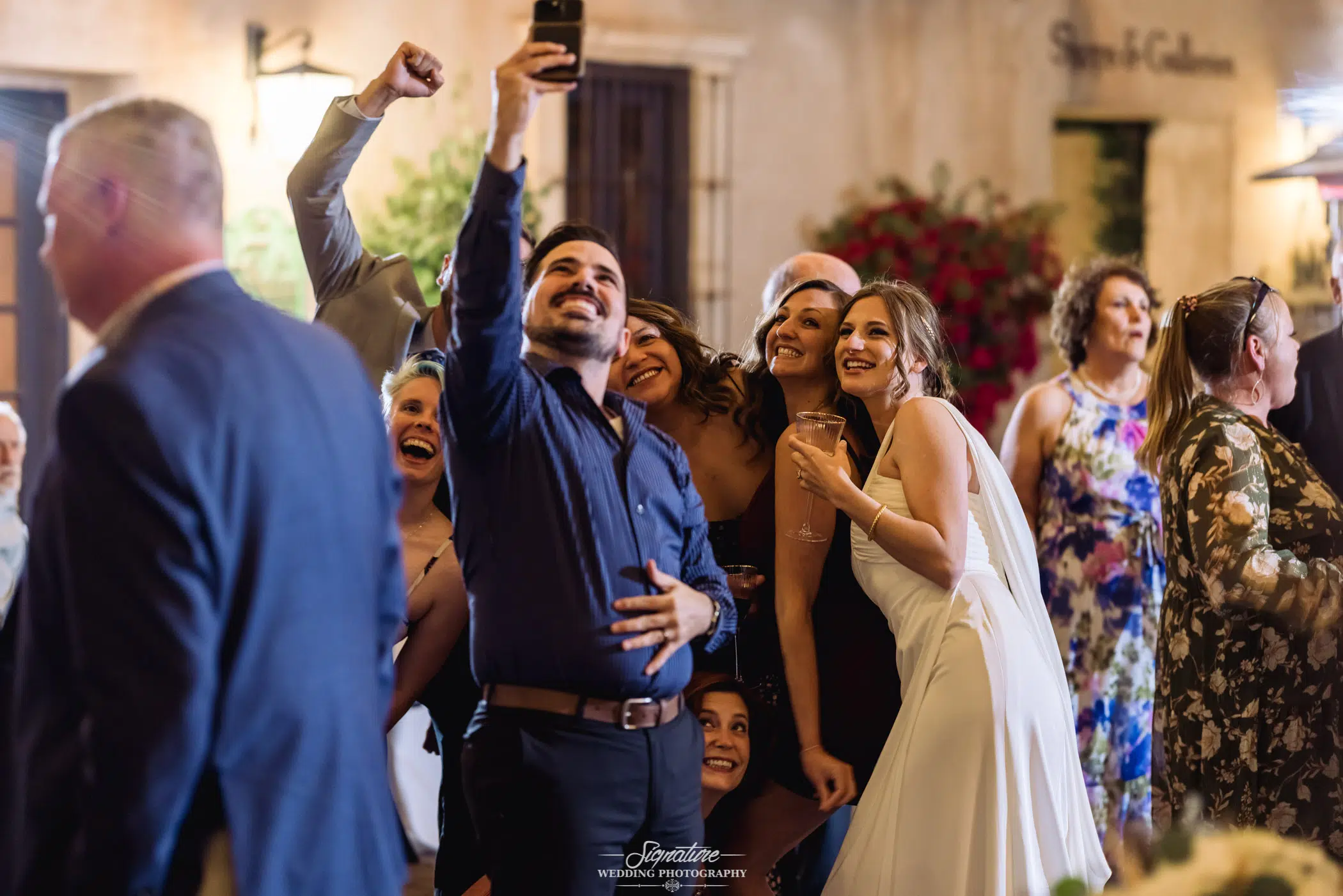 Wedding guests taking selfies with bride