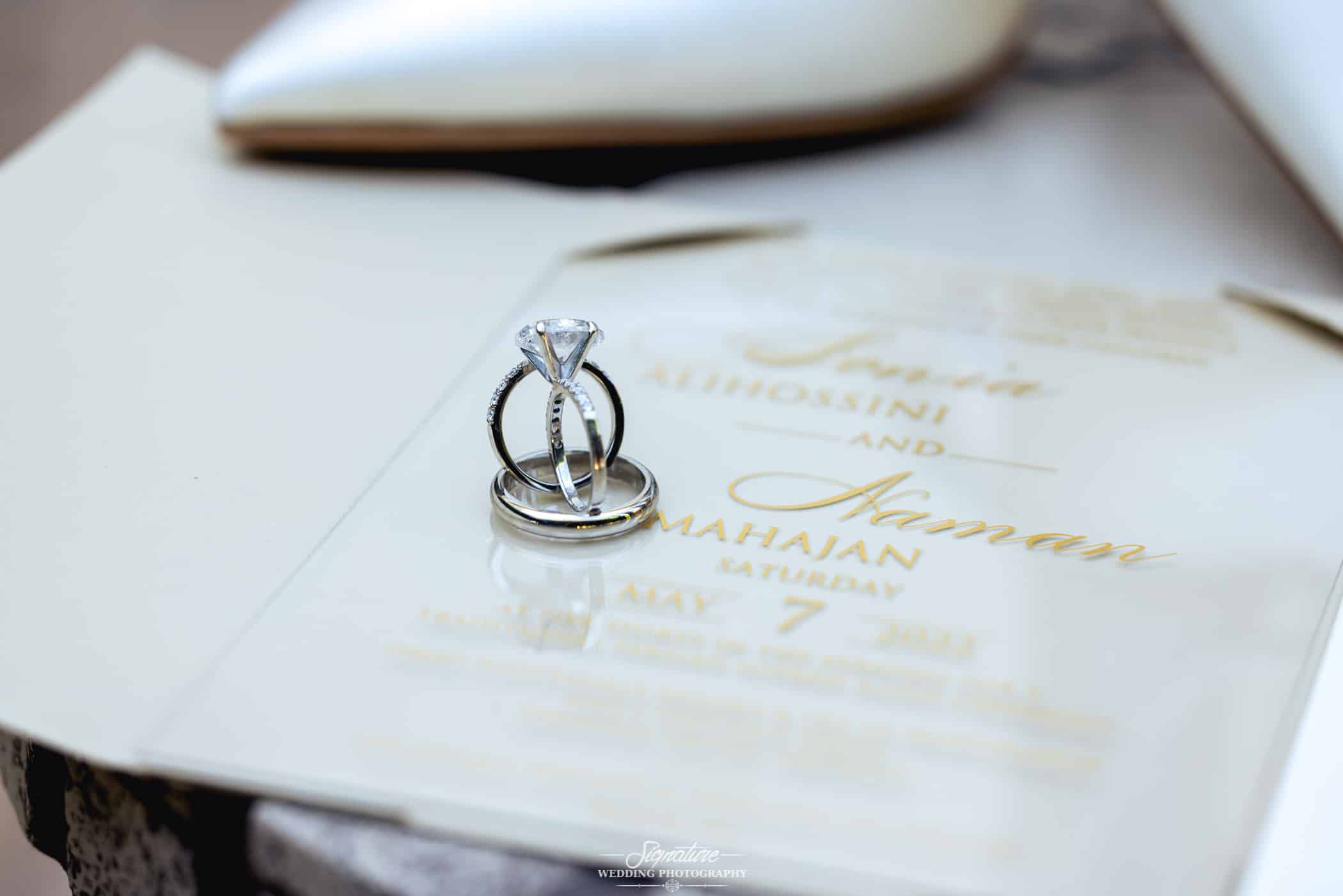 Close up detail shot of wedding rings and invitation