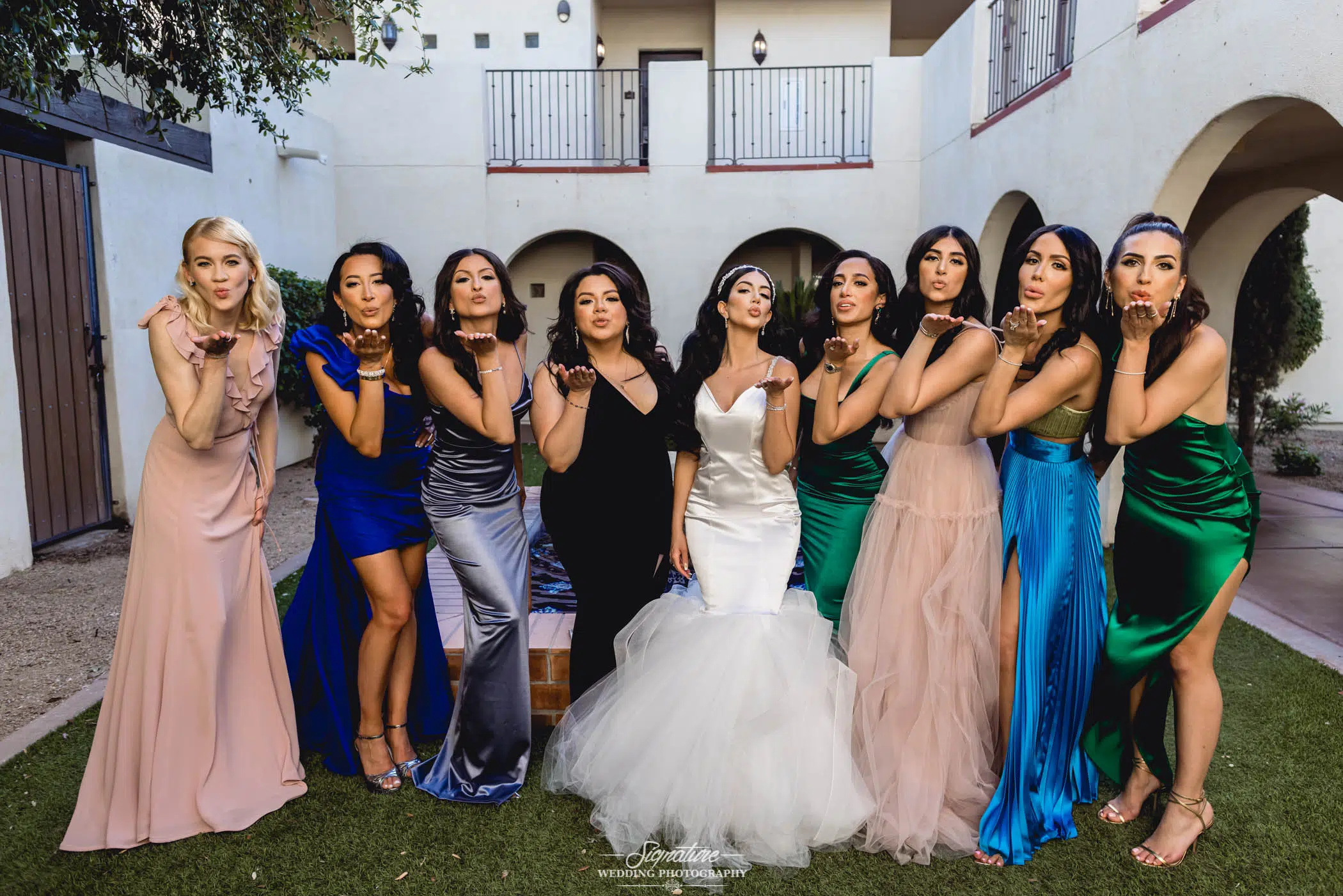 Bride and bridesmaids blowing kisses at camera