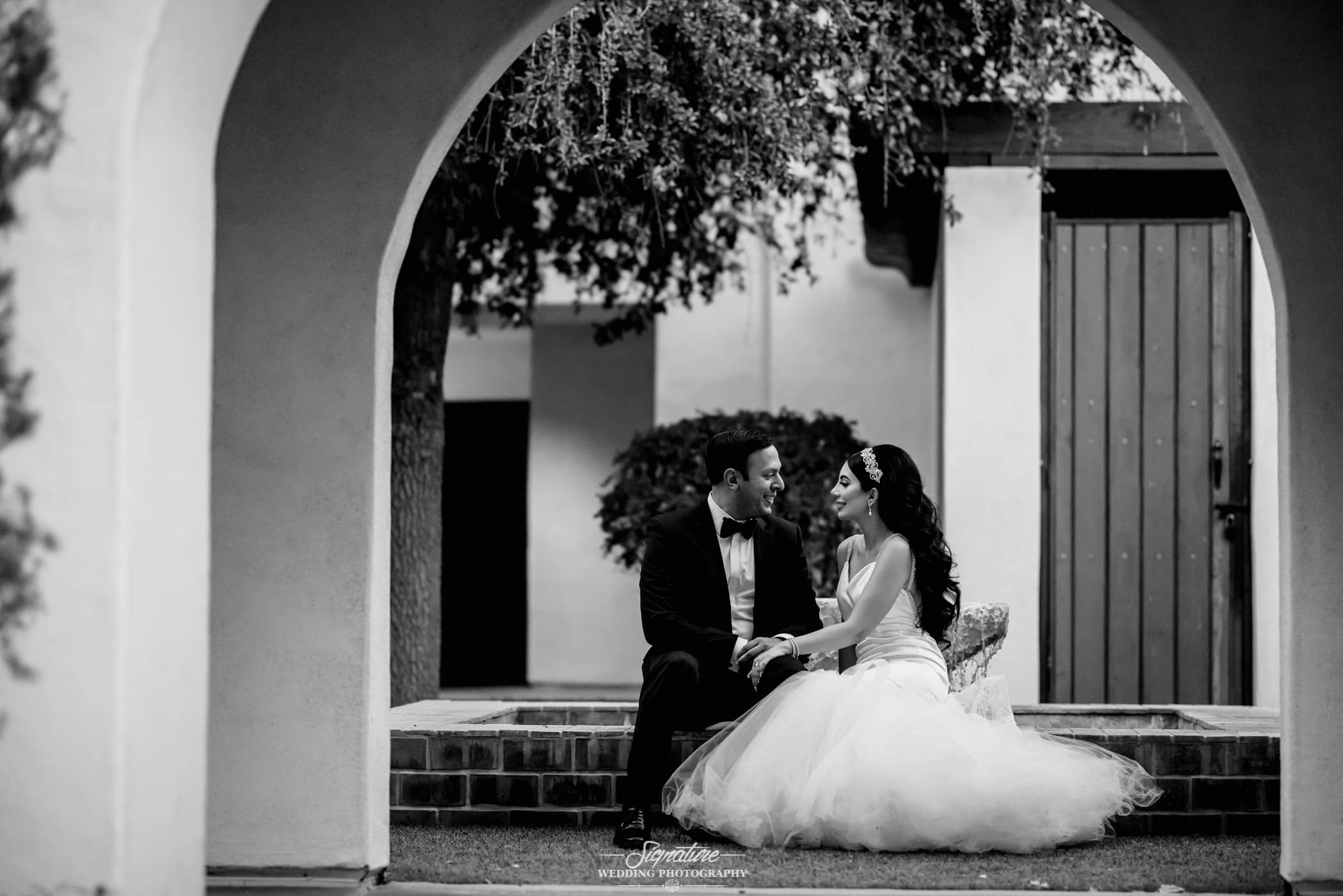 Bride and groom sitting looking at each other black and white