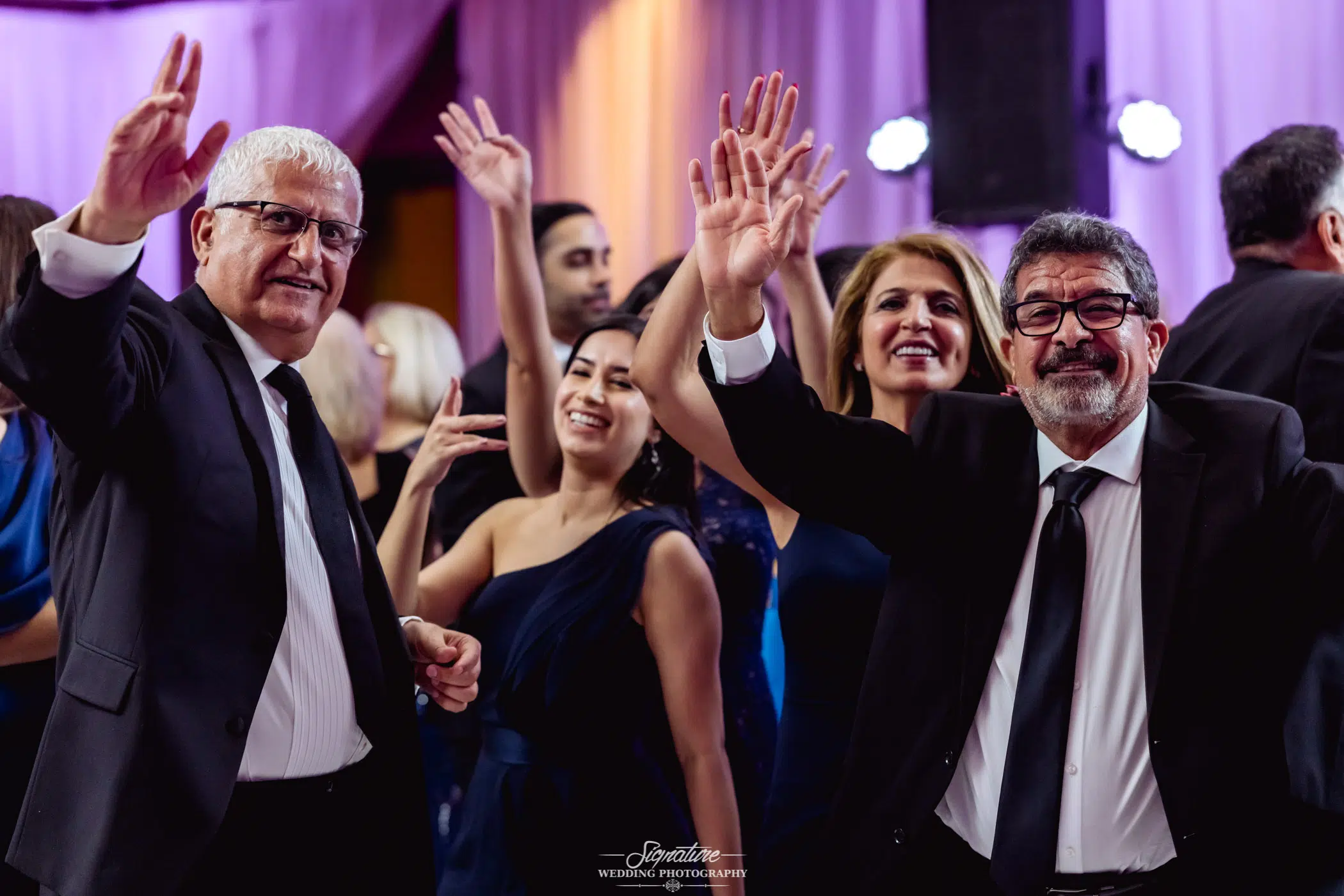 Image by Signature Wedding Photography Wedding guests smiling with hands up