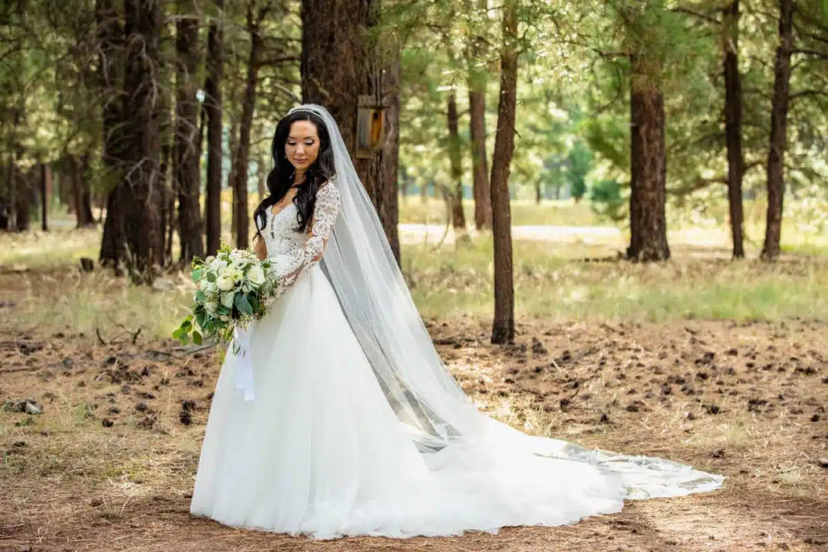 Bride looking down in forest