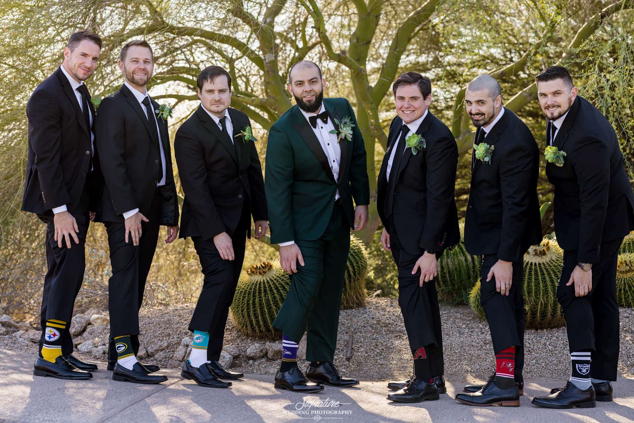 Groom and groomsmen showing off team socks