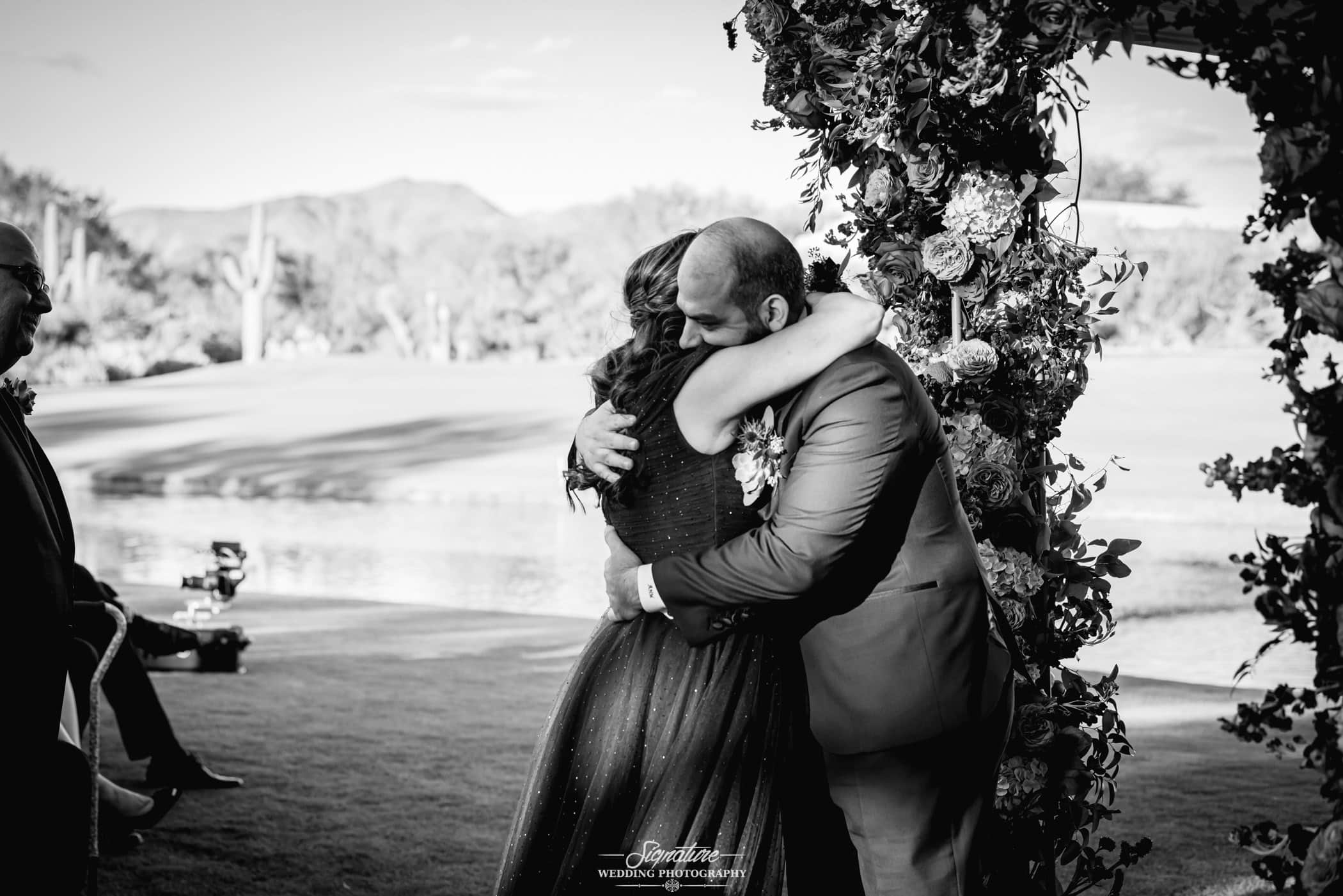 Groom hugging mother black and white