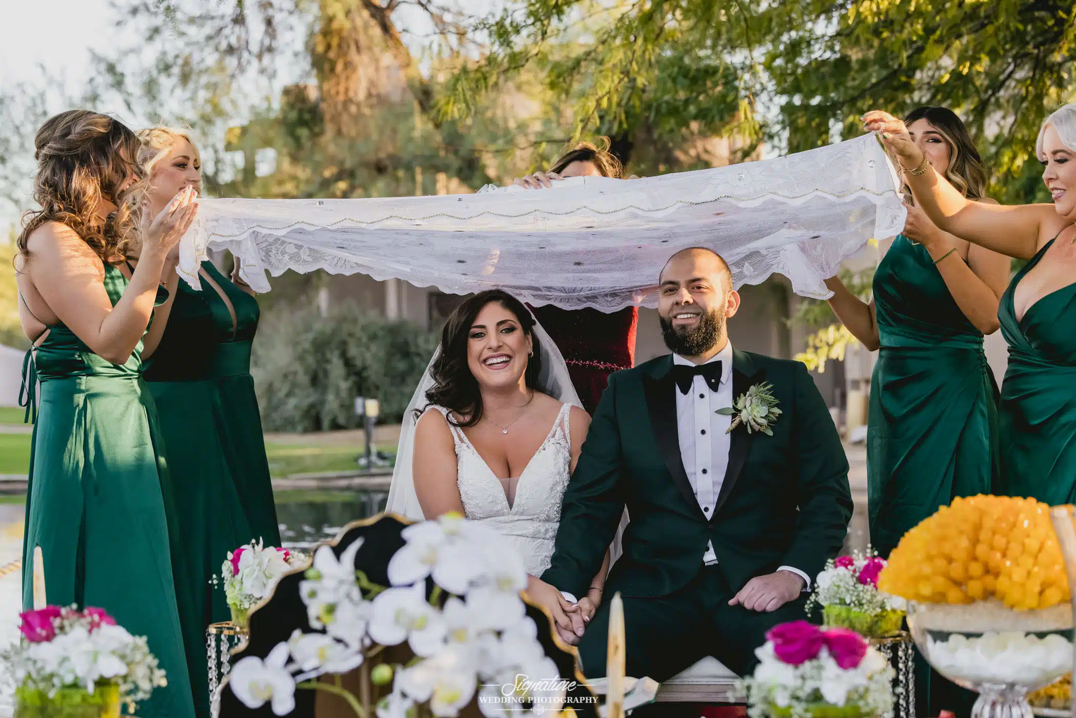 Bride and groom sitting under canopy