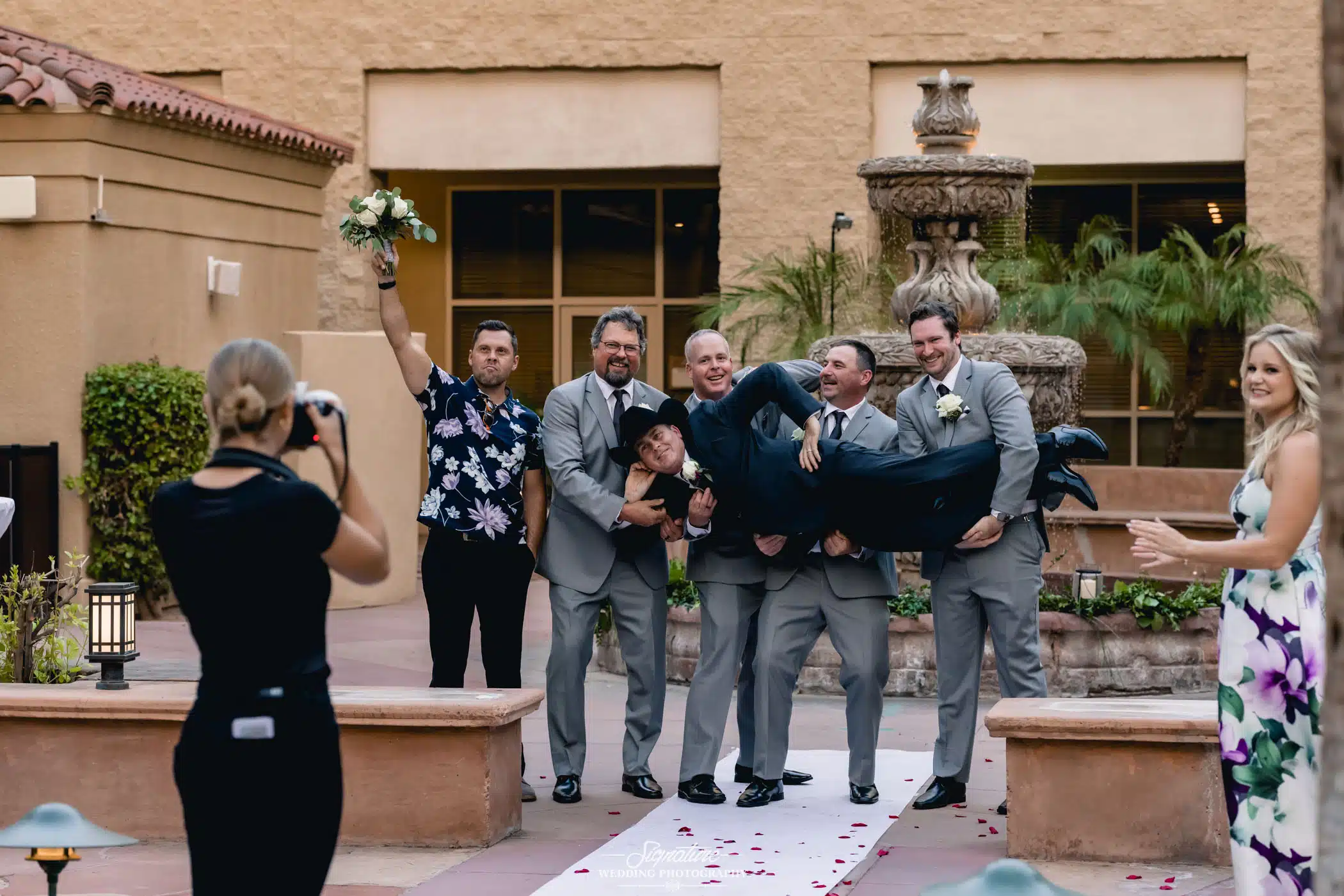Groomsmen holding up groom