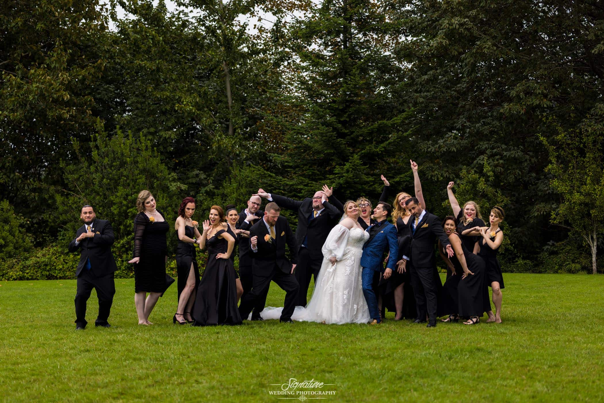 Bride and groom with wedding party doing funny pose