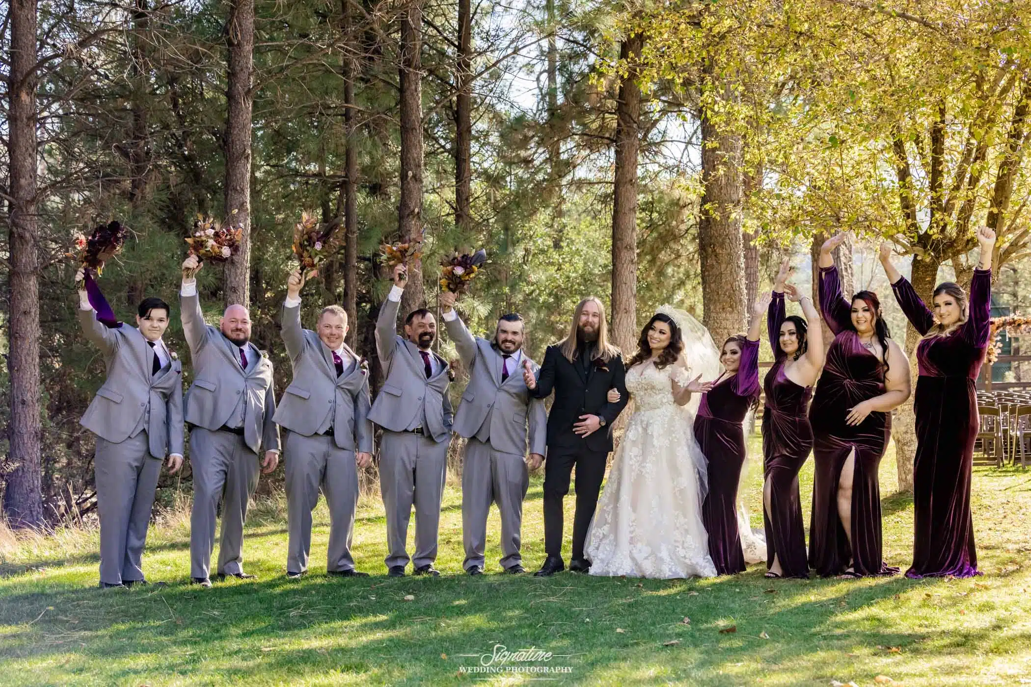 Bride and groom with wedding party arms up