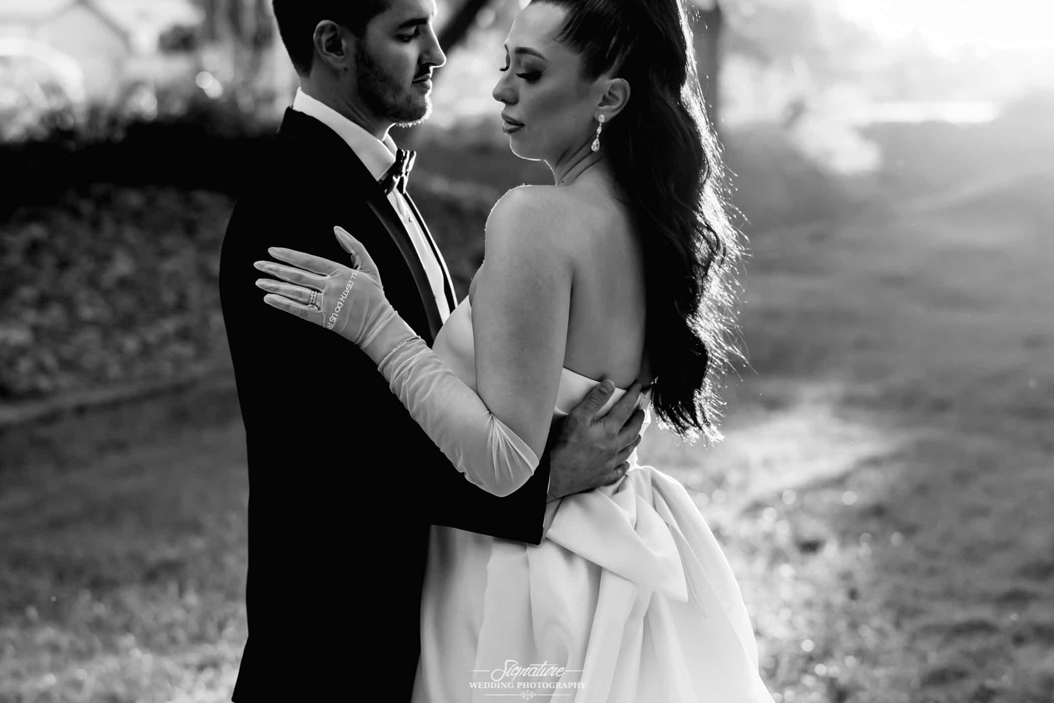 Bride and groom with arms around each other black and white
