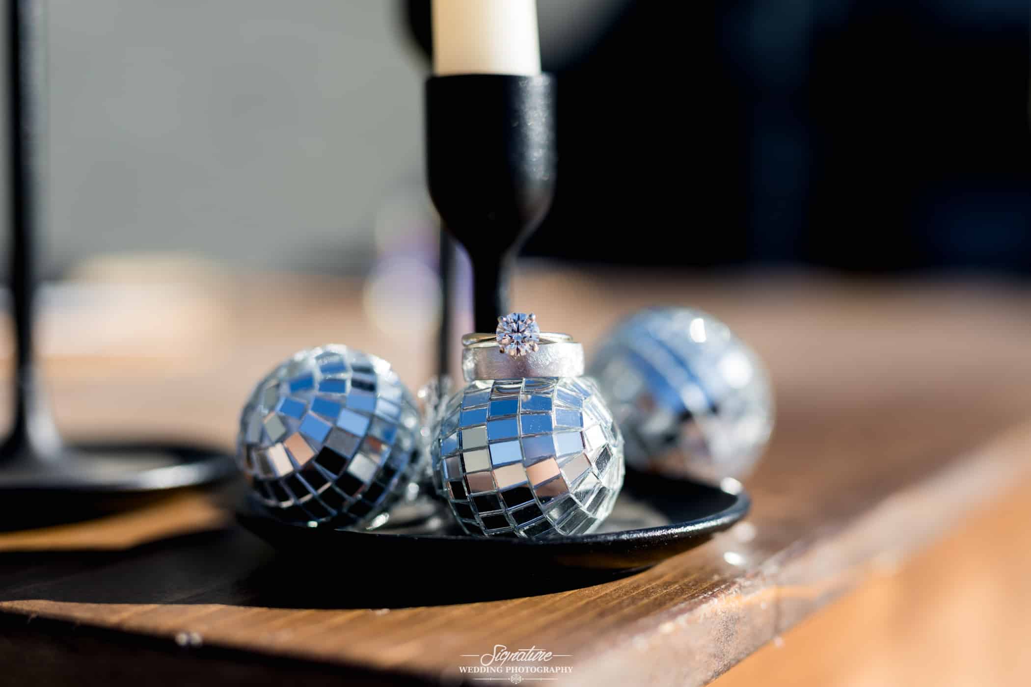 Close up detail of wedding rings on disco balls
