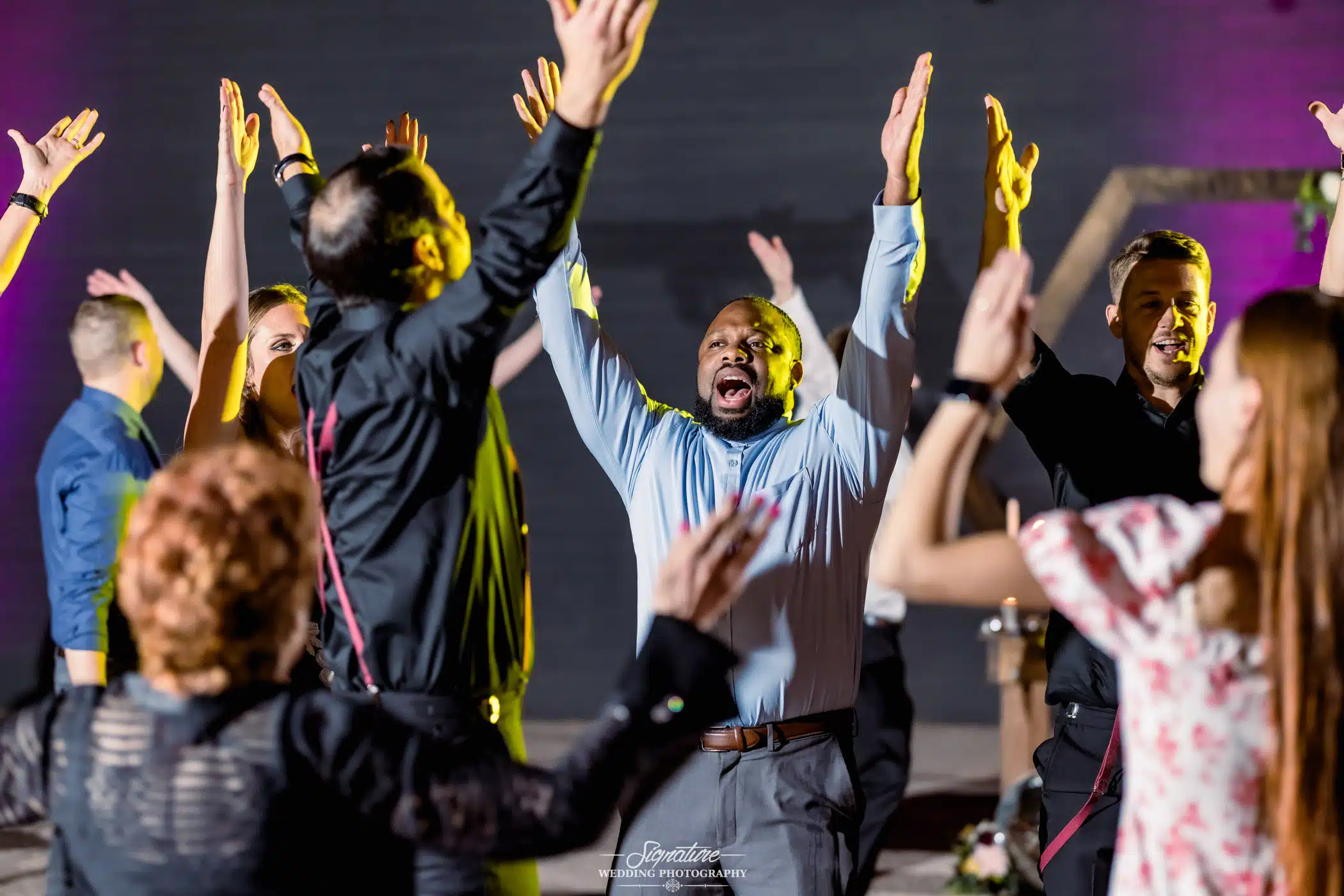 Wedding guests dancing with arms up