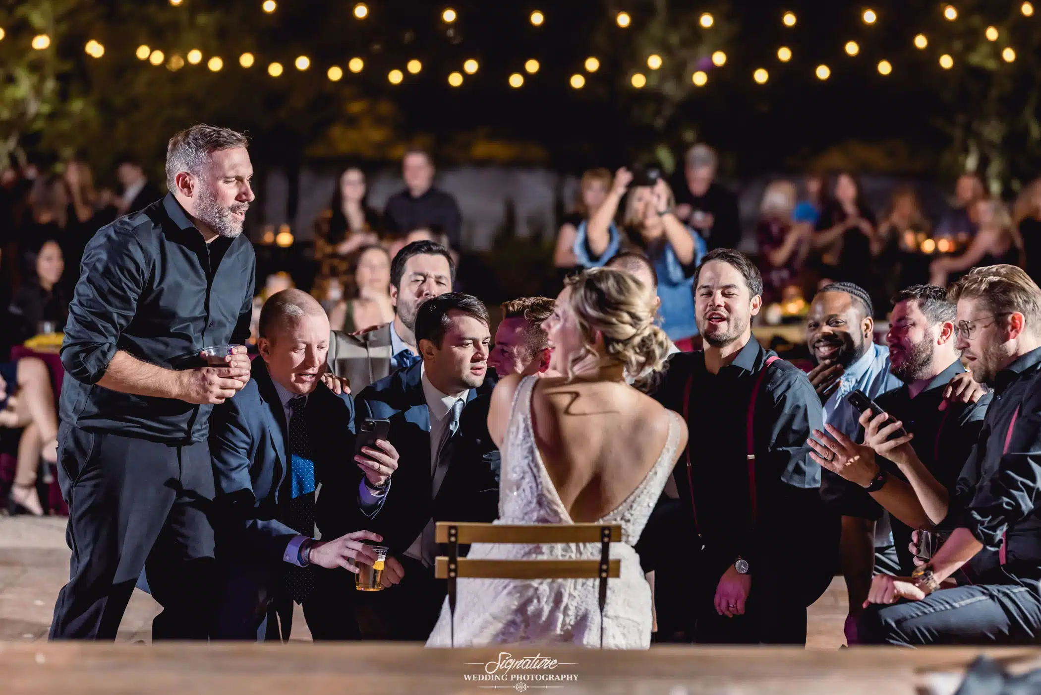 Groom and groomsmen kneeling around bride