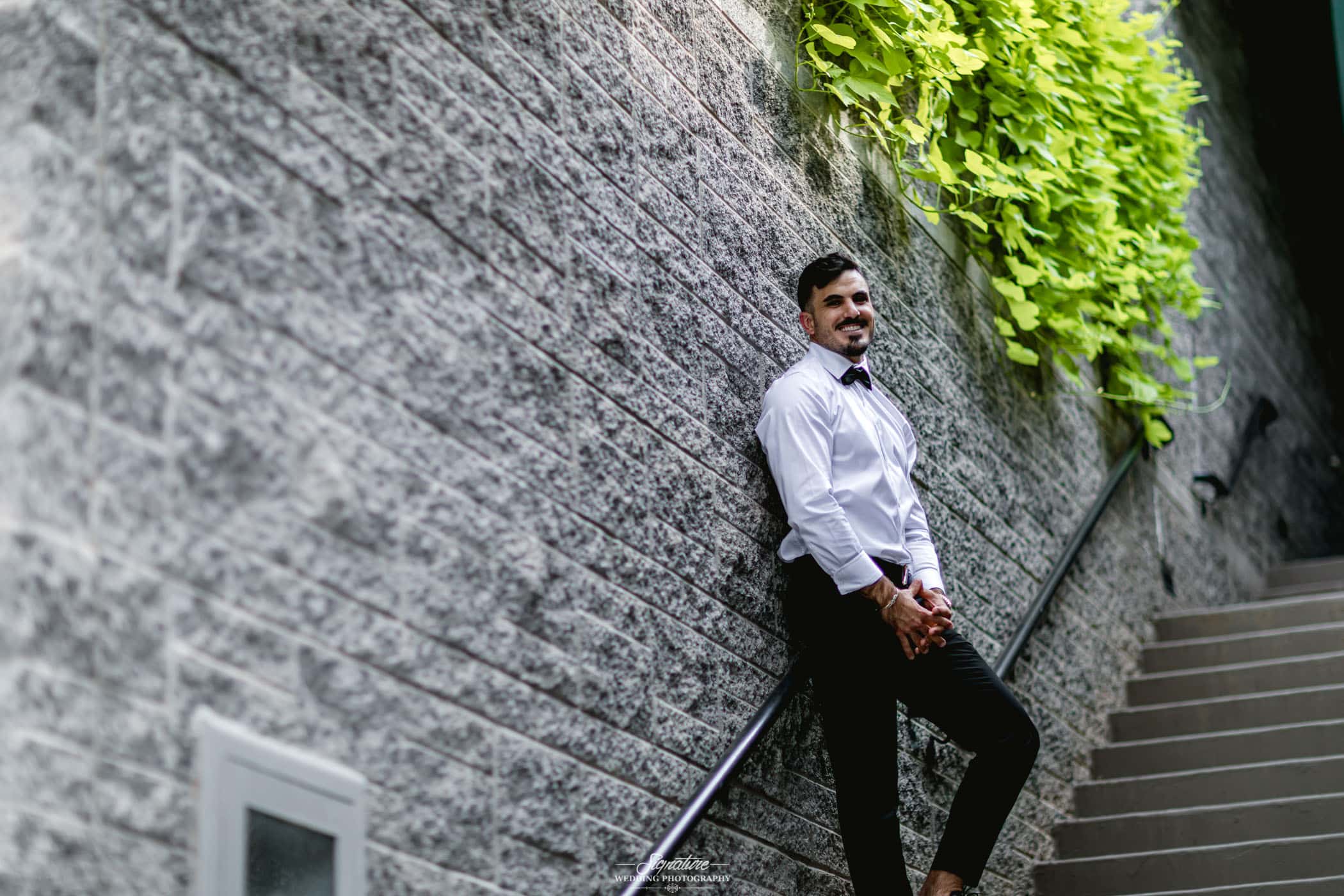 Groom smiling standing on stairs