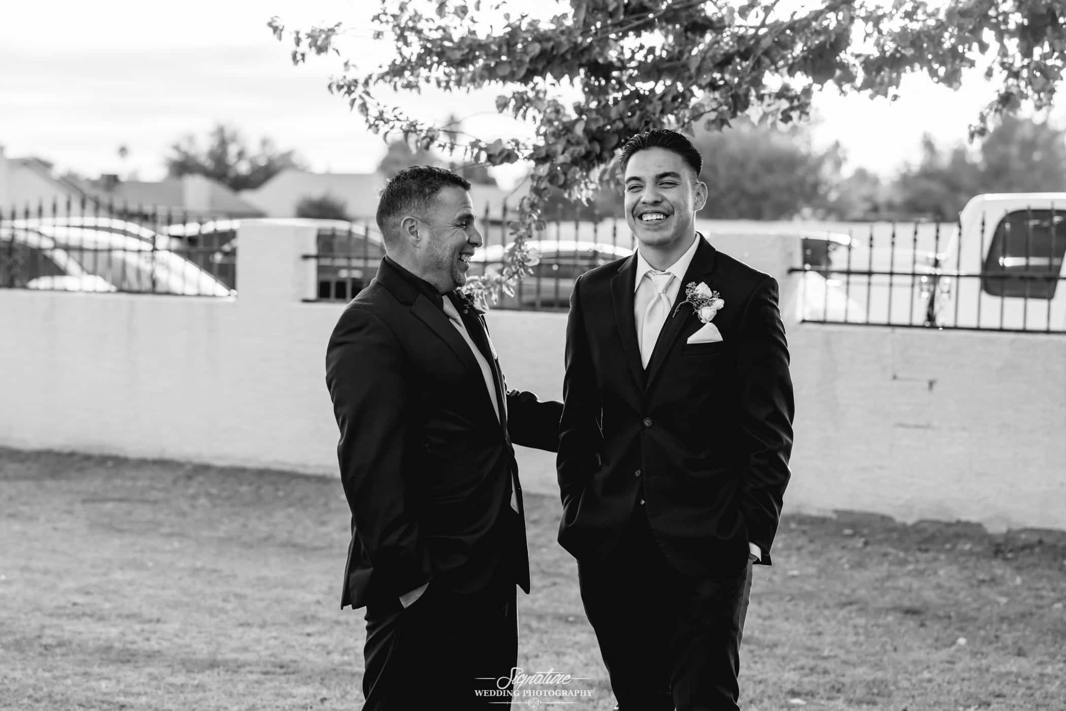 Groom and best man smiling black and white