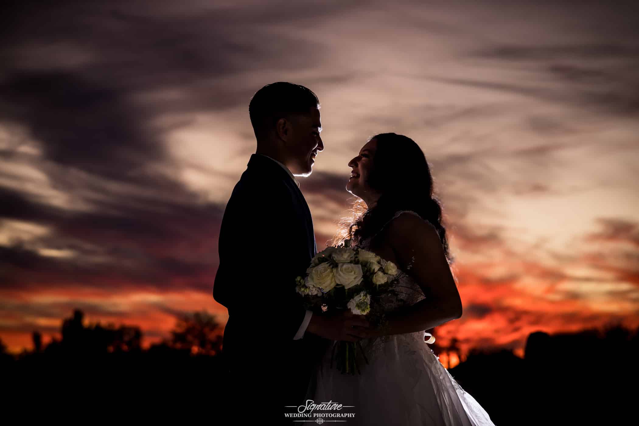 Bride and groom looking at each other at sunset