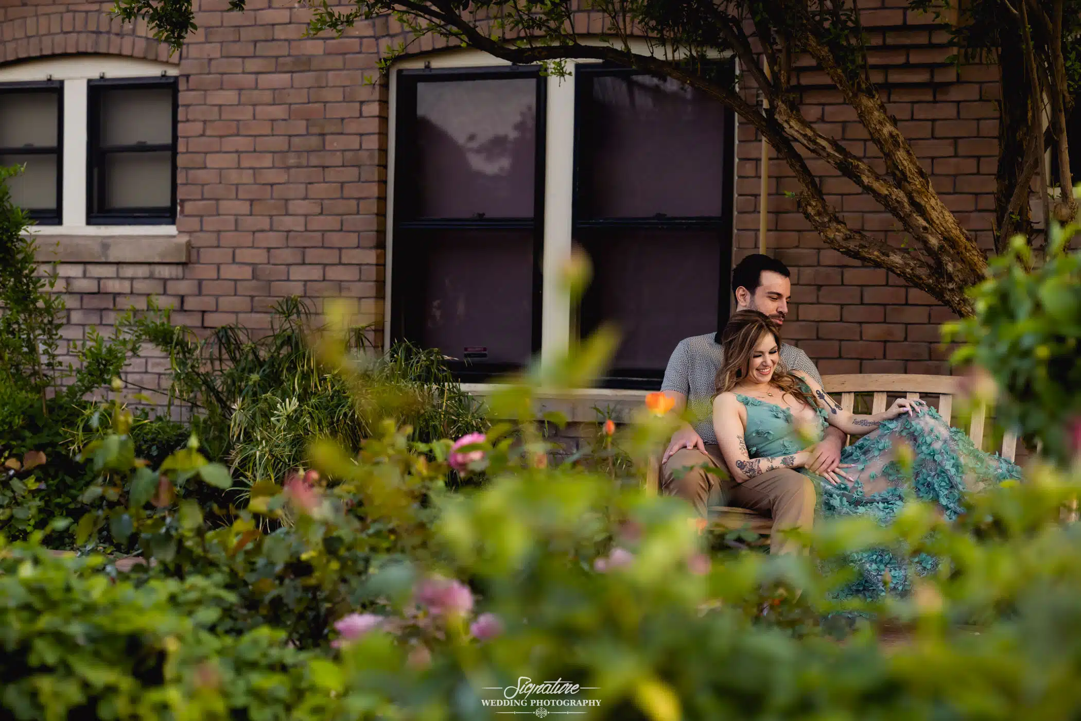 Image by Signature Wedding Photography Couple cuddling on bench outside