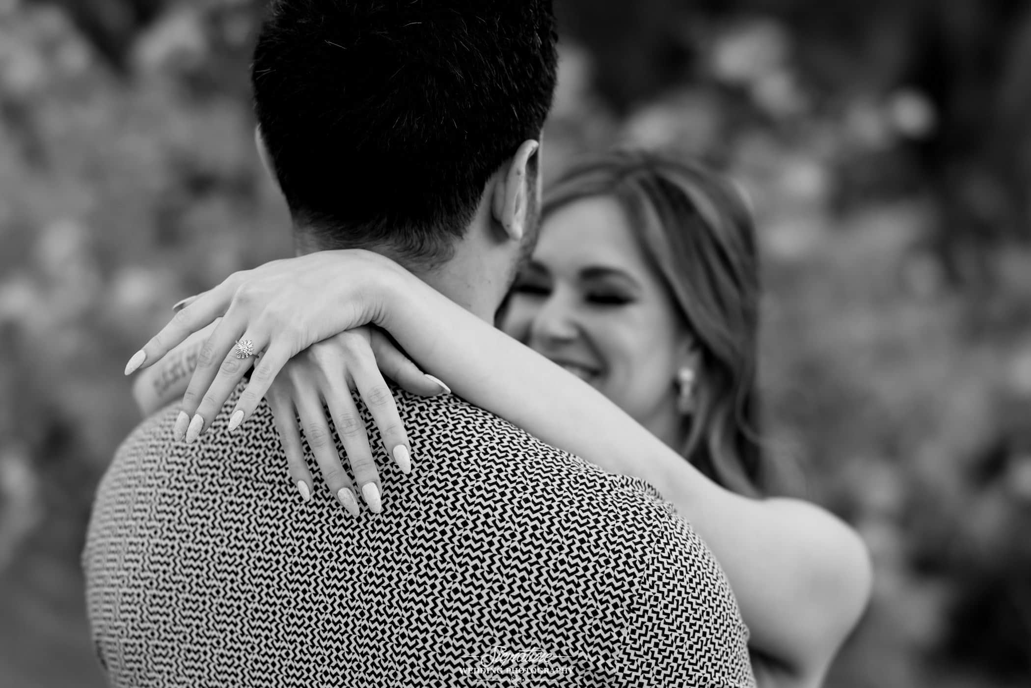 Woman's arm around man's shoulders black and white