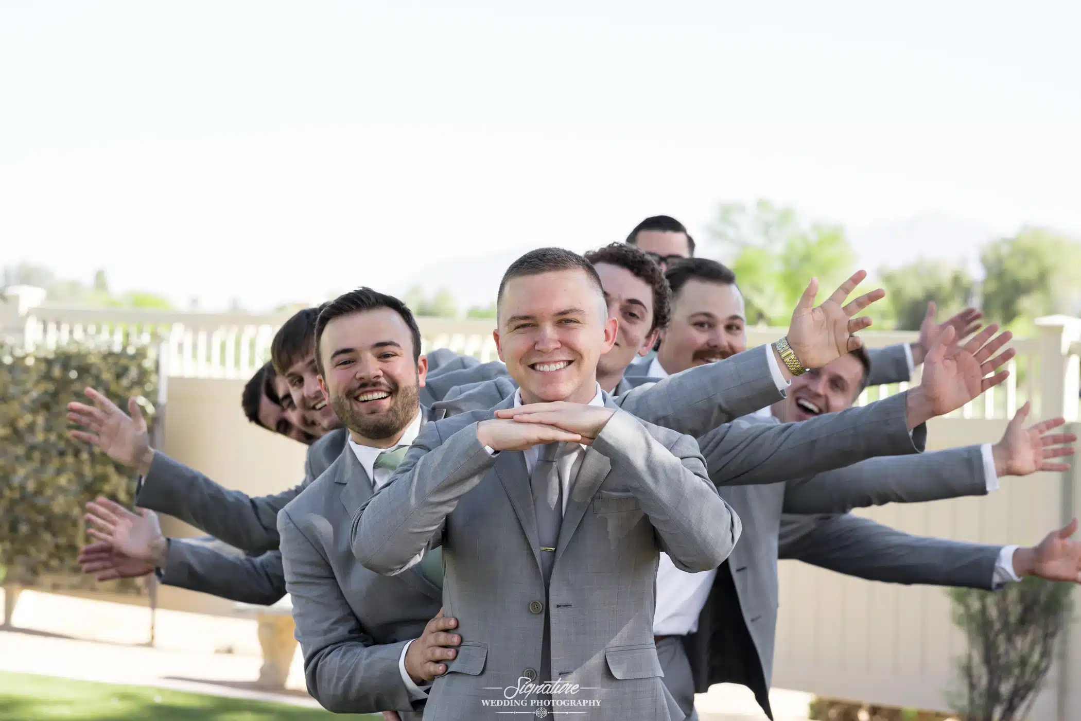 Image by Signature Wedding Photography Groom with groomsmen funny pose