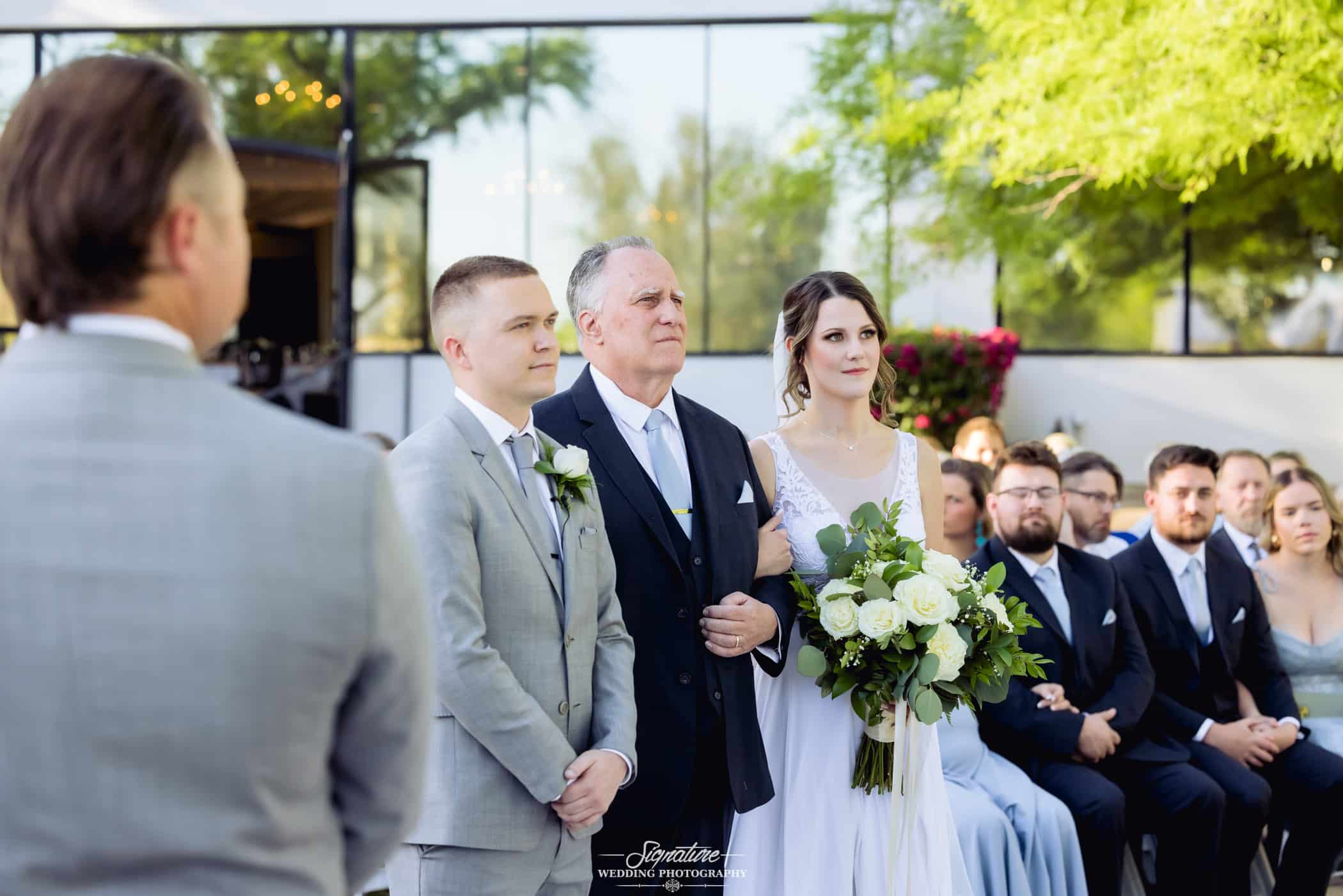 Father standing with bride and groom 