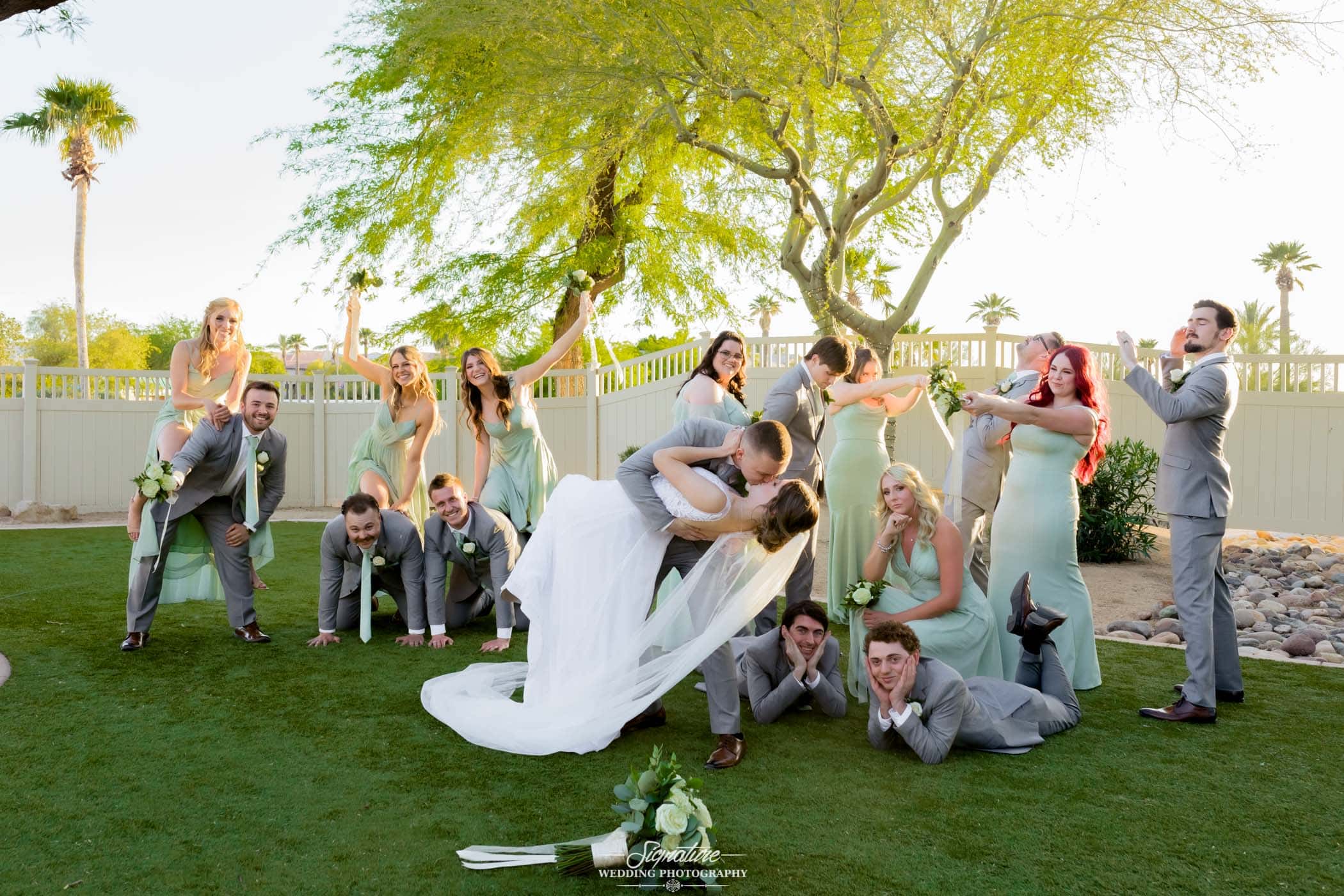 Bride and groom with wedding party funny pose