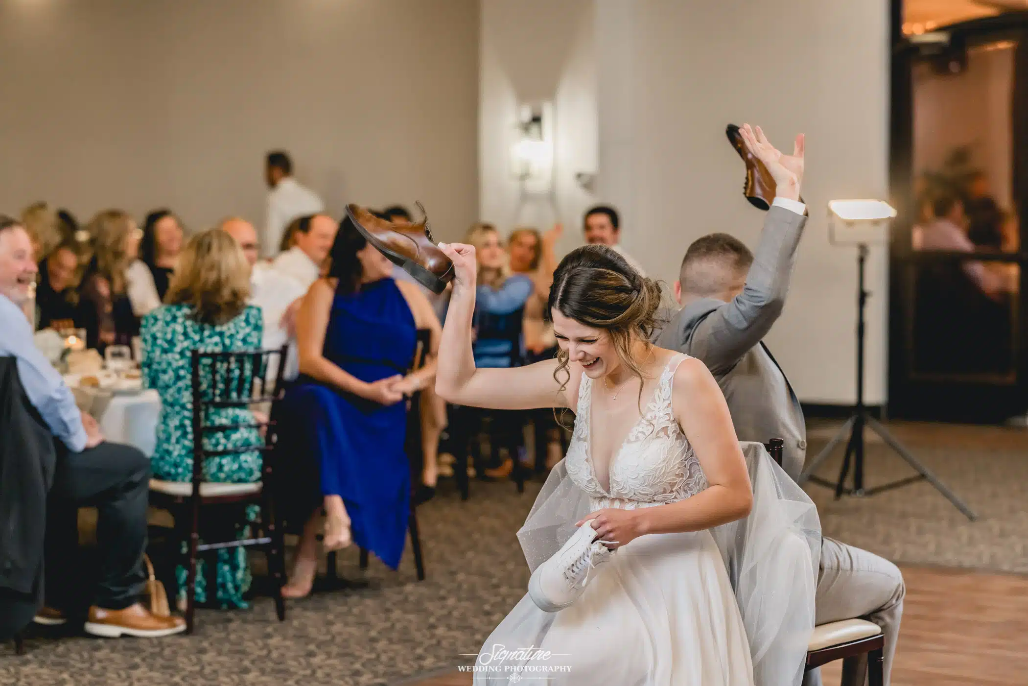 Image by Signature Wedding Photography Bride and groom playing wedding game during reception