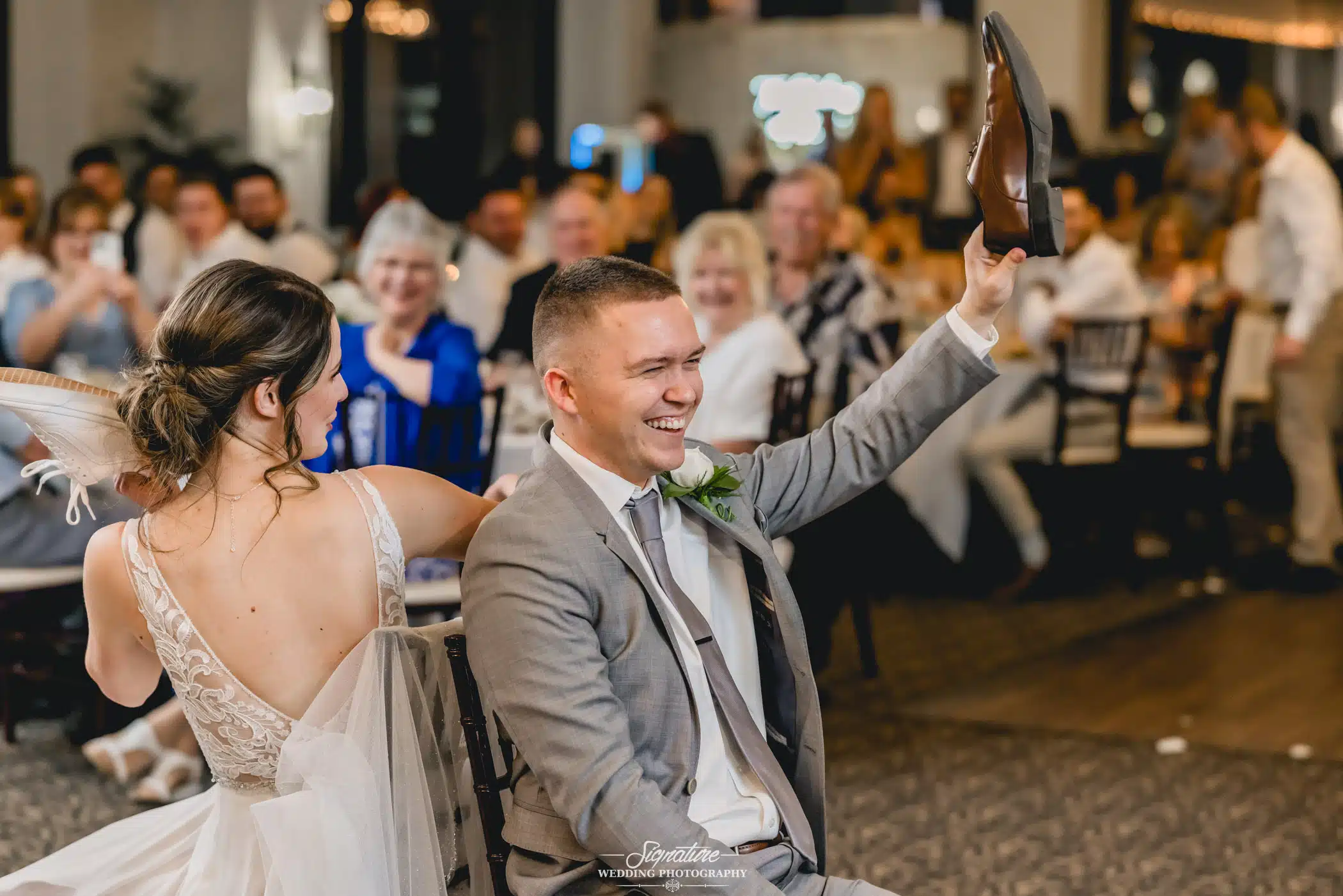 Image by Signature Wedding Photography Bride and groom playing wedding game during reception