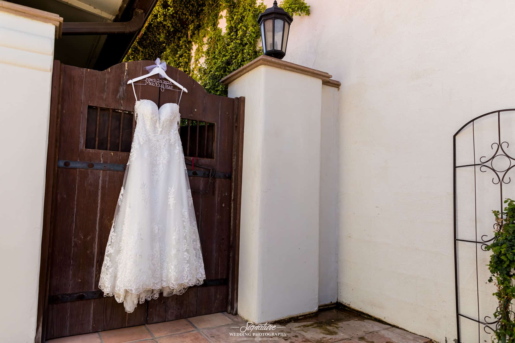 Wedding dress hanging from wooden gate