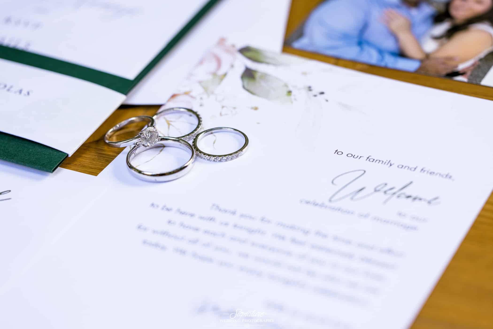 Close up detail shot of rings and invitation