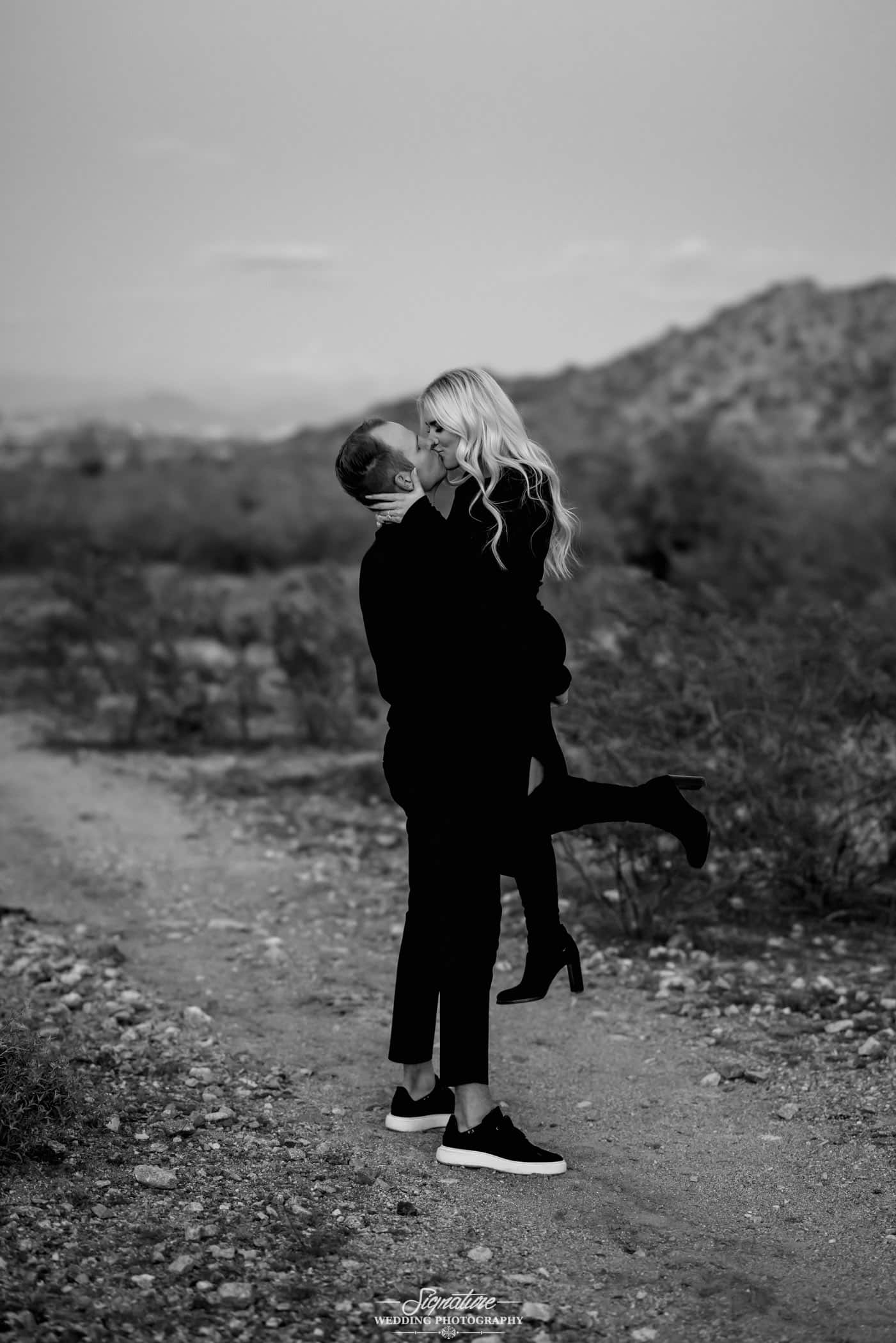 Man picking up woman black and white engagement photo