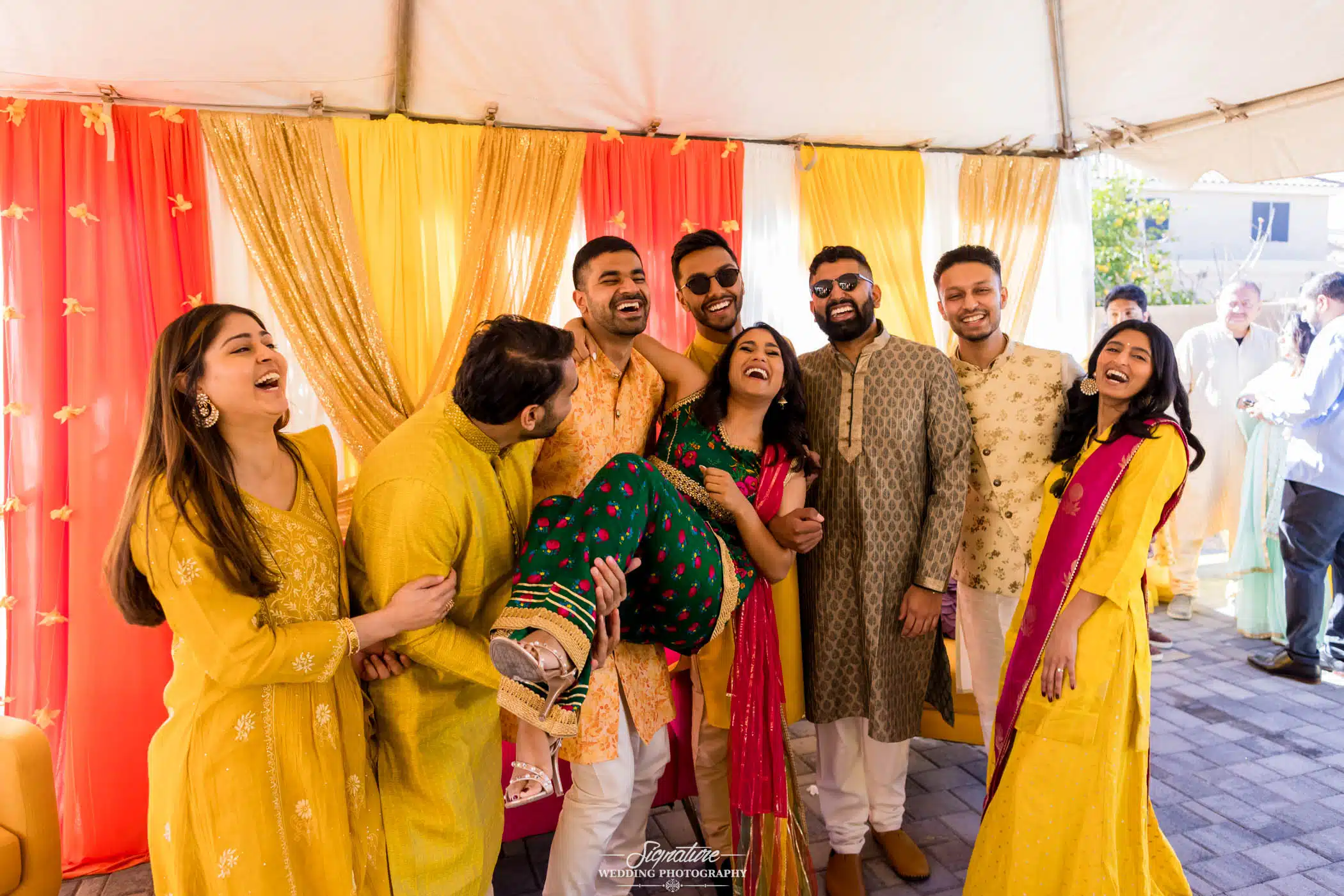 Image by Signature Wedding Photography Bride and groom with family at haldi ceremony