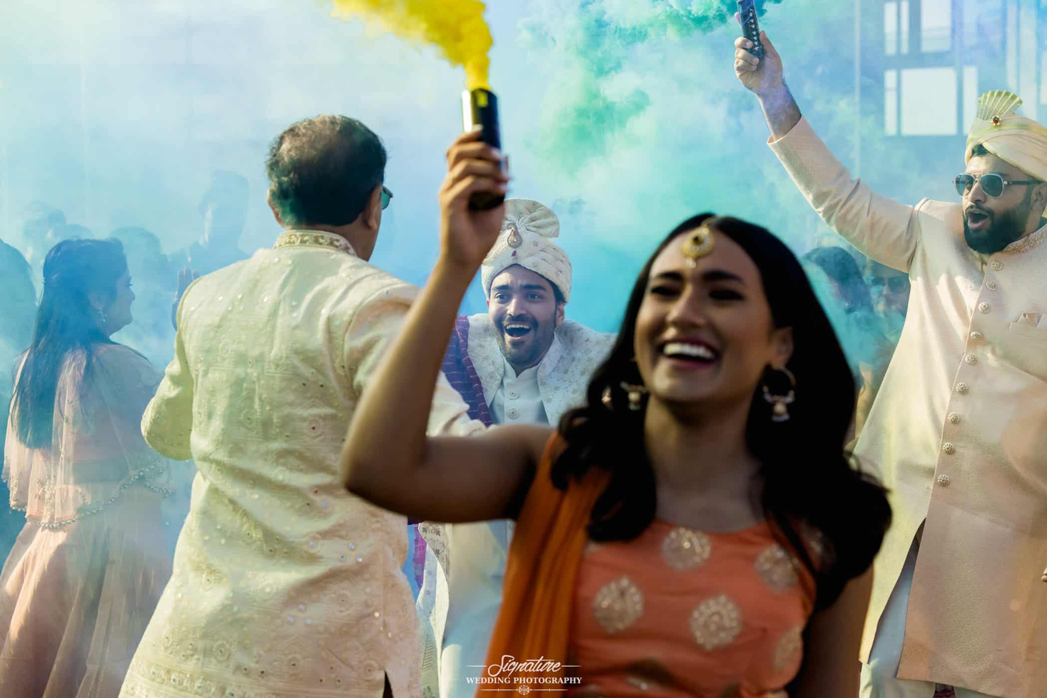 Wedding guests with colored smoke flares
