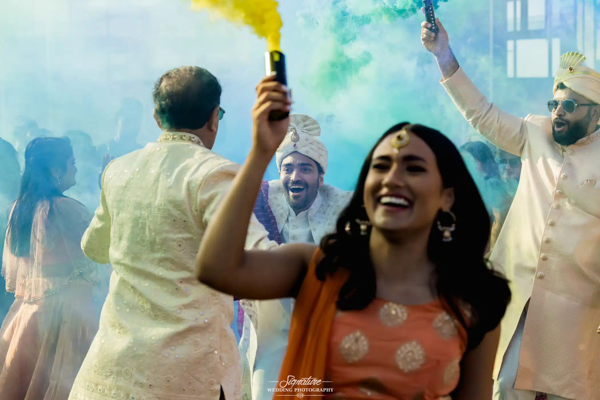 Image by Signature Wedding Photography Wedding guests with colored smoke flares
