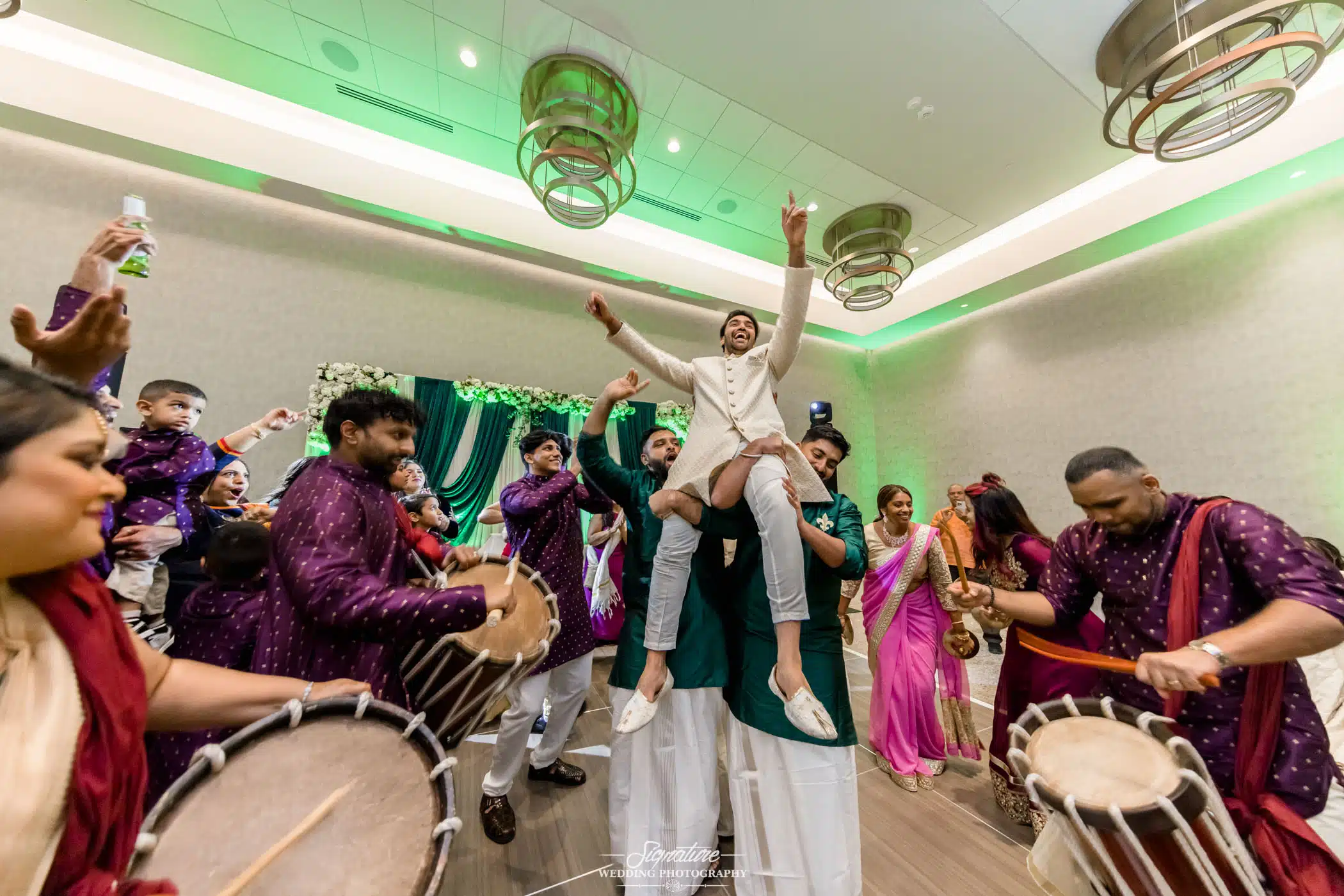 Image by Signature Wedding Photography People picking groom up in drum circle