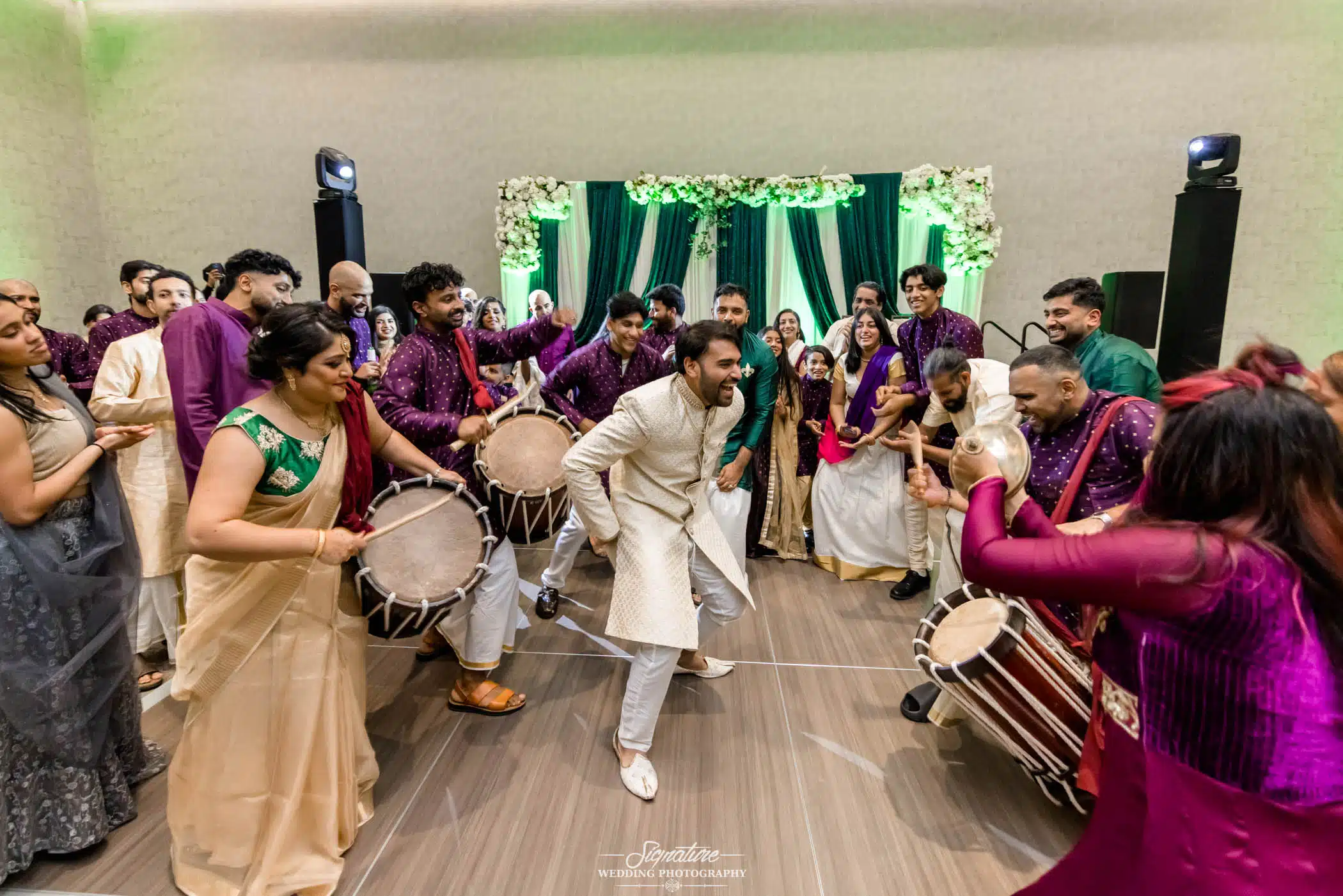 Image by Signature Wedding Photography Groom dancing in drum circle