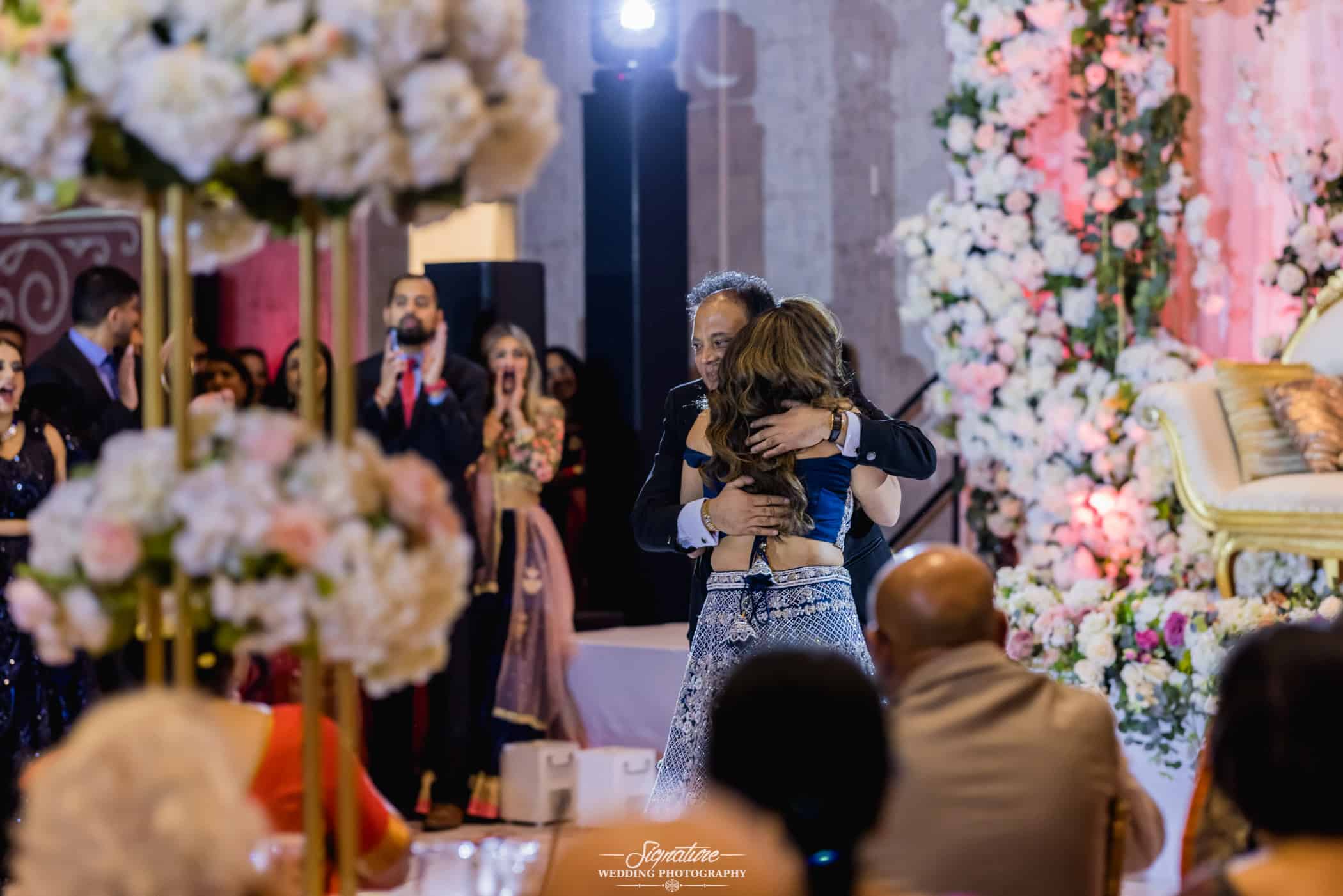 Bride hugging dad at reception