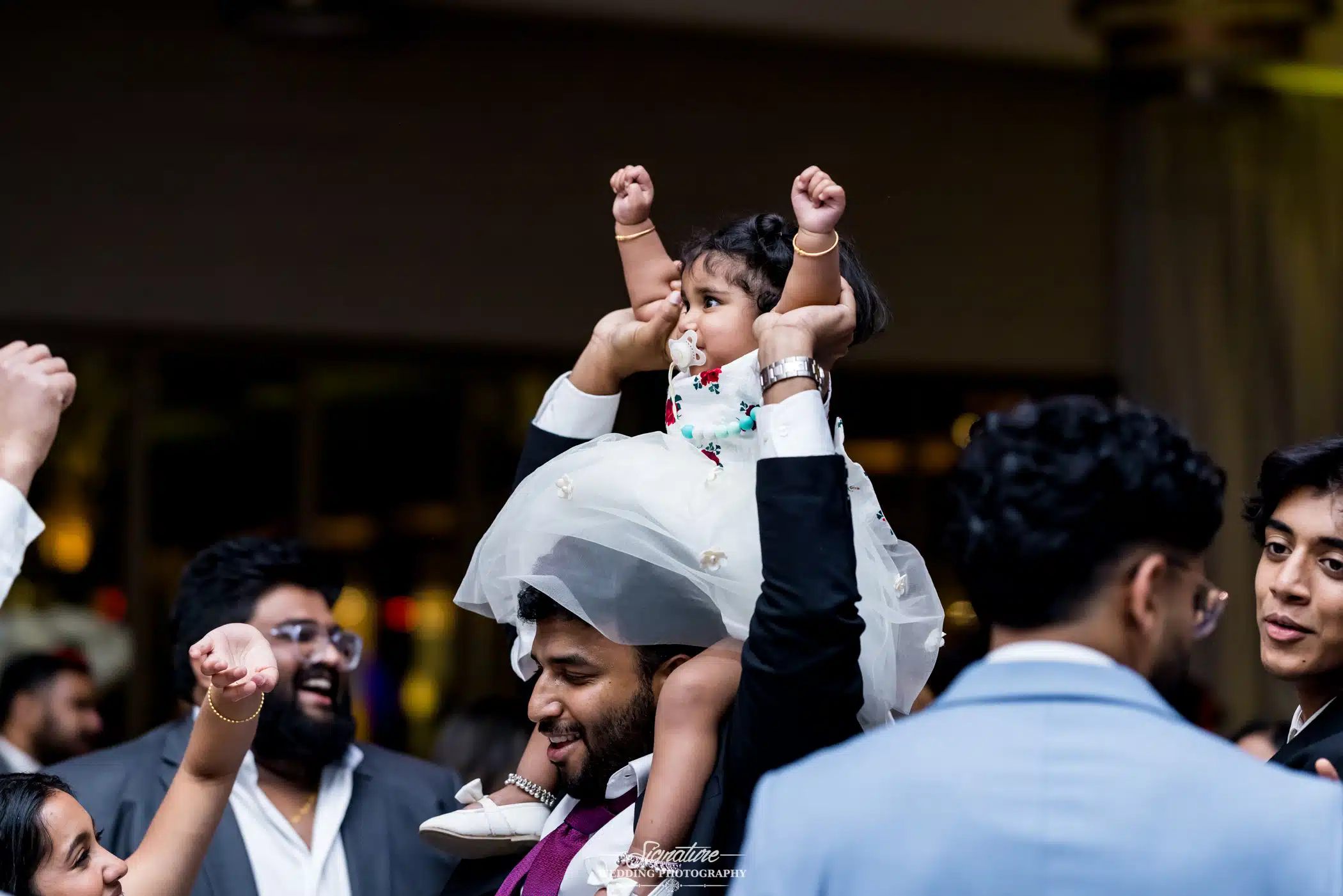 Image by Signature Wedding Photography Flower girl on grooms shoulders