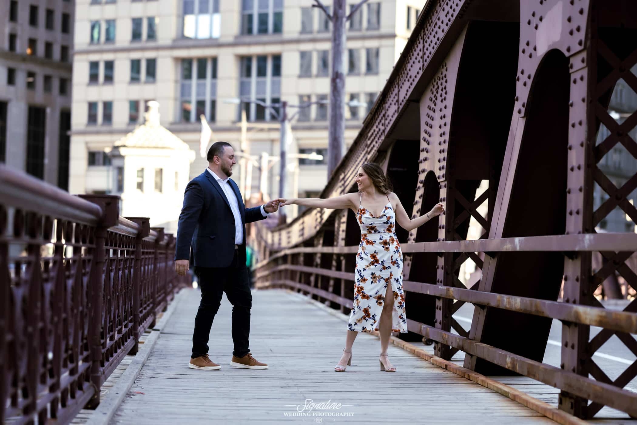 engagement photo of couple dancing on a bridge in chicago
