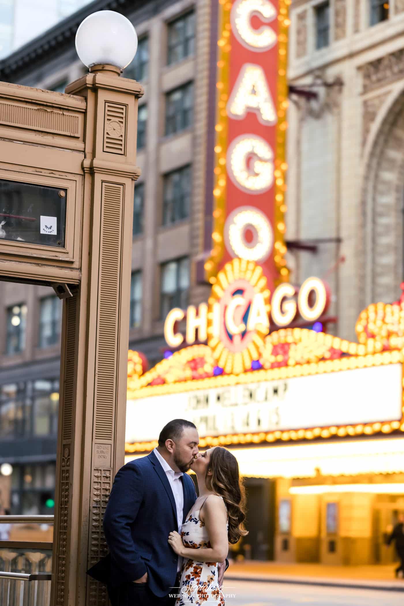 engagement photo of couple with the chicago theater in the background