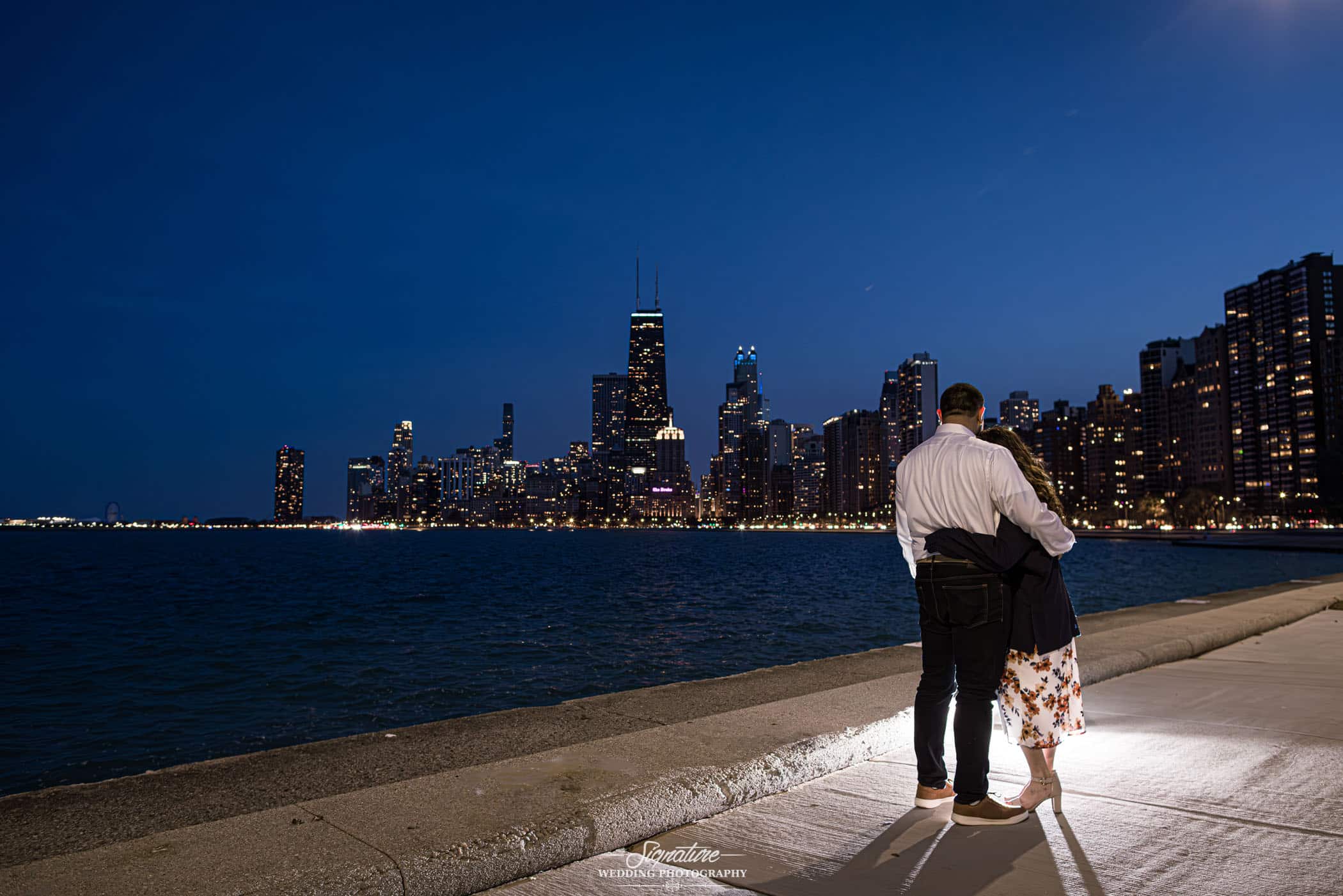 couple overlooking cityscape at night