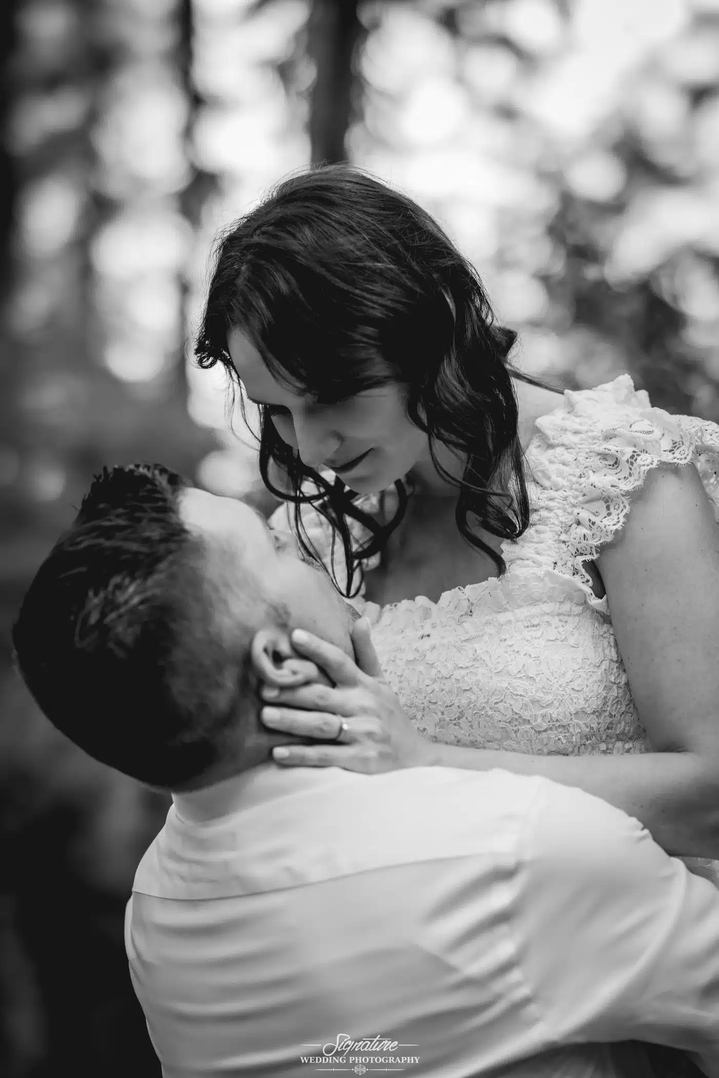 Image by Signature Wedding Photography close up of man holding up his fiancée while she looks at him intently in his eyes