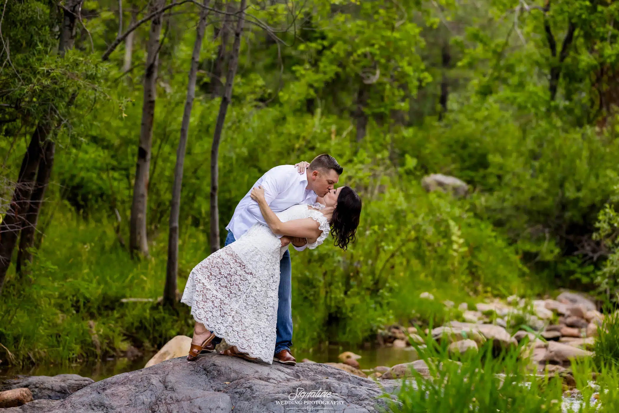 Image by Signature Wedding Photography man dip kissing his fiancée