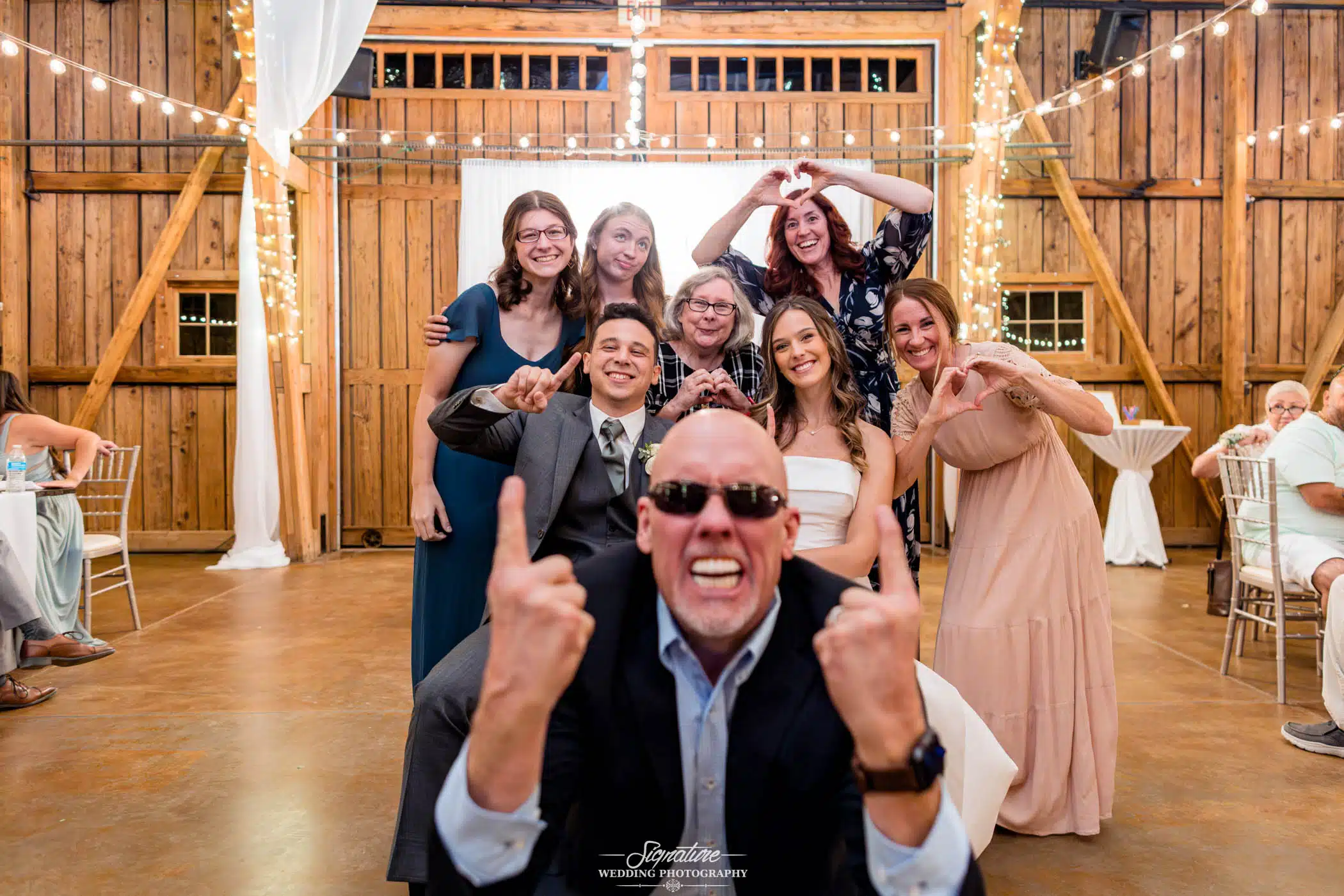 Image by Signature Wedding Photography candid group photo of bride and groom with friends